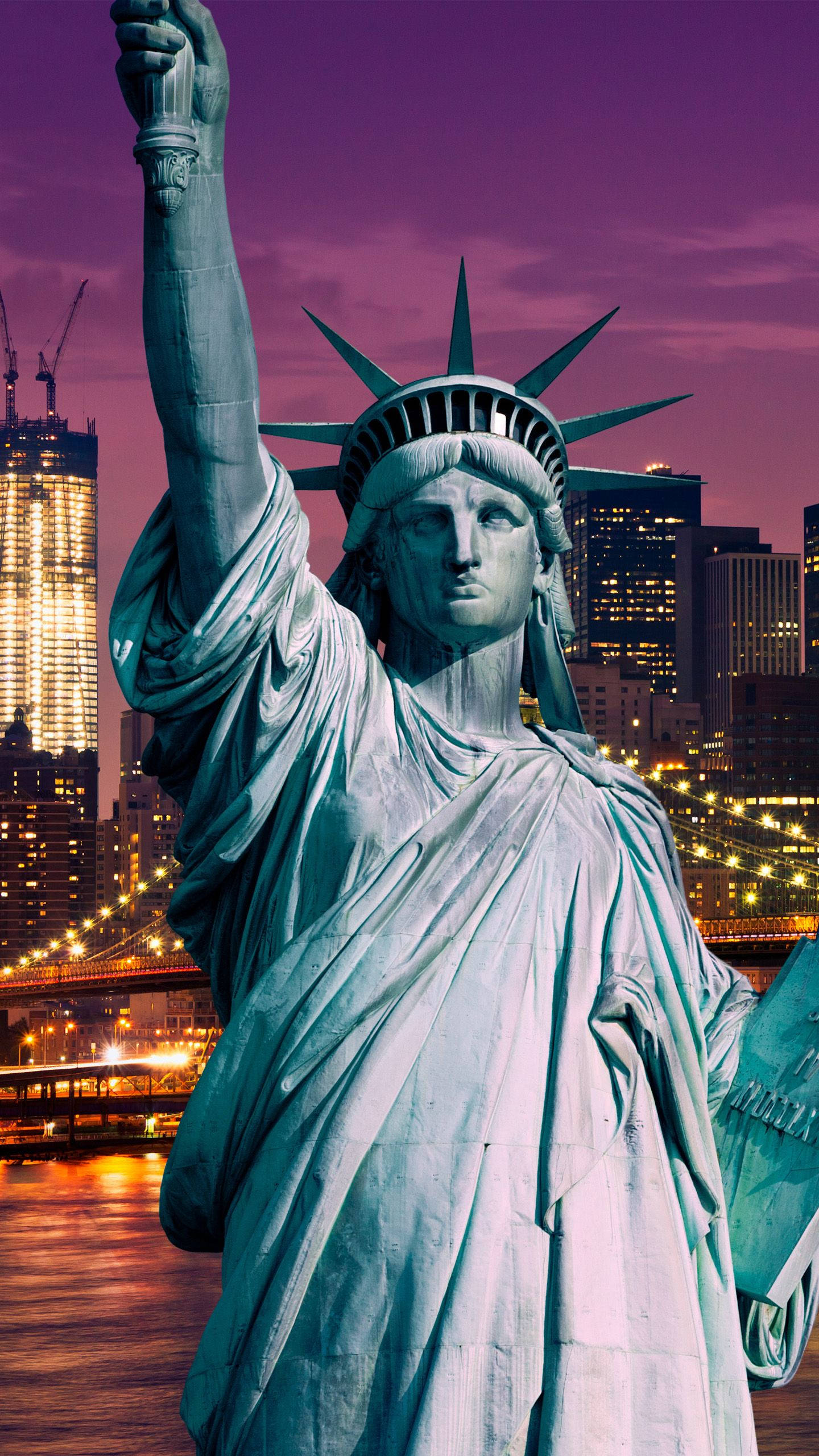 New York 桌布 壁紙 — 自由女神像在充滿活力的紫色暮色天空下高高聳立，背後是燈火通明的紐約市天際線。