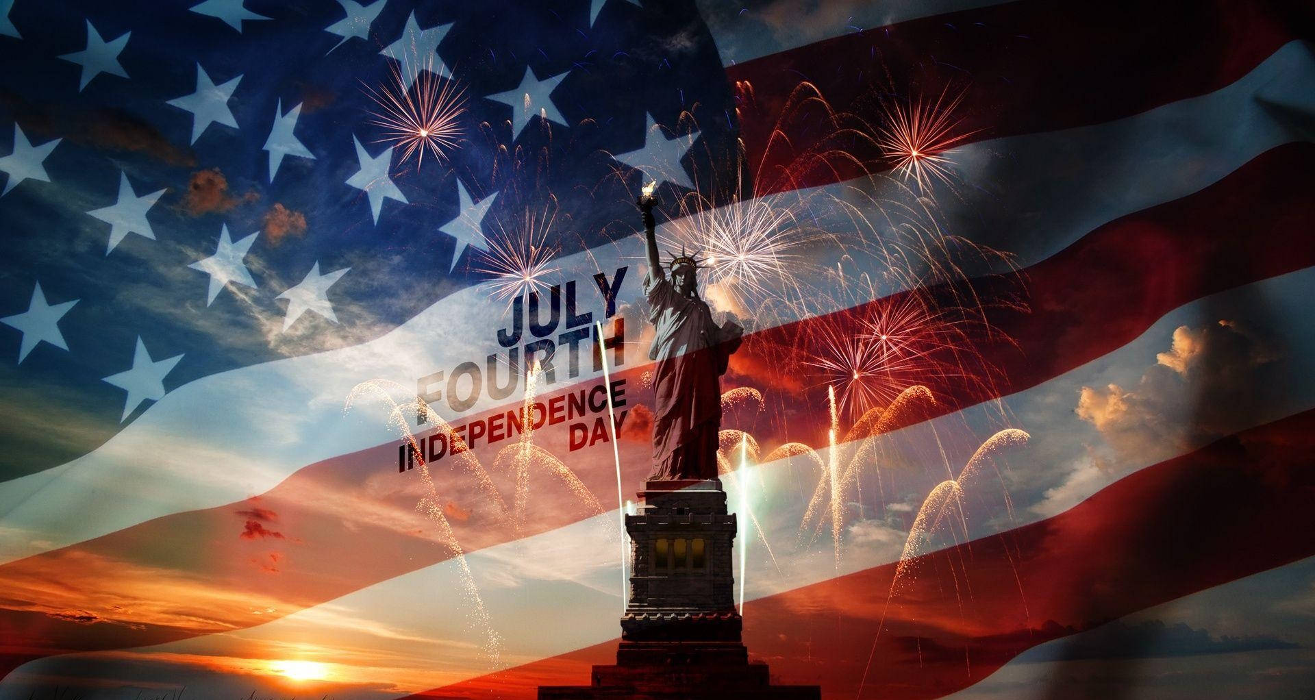 Independence 桌布 壁紙 — 自由女神像在夕陽天空下高高聳立，上面覆蓋著美國國旗和慶祝七月四日的煙火。