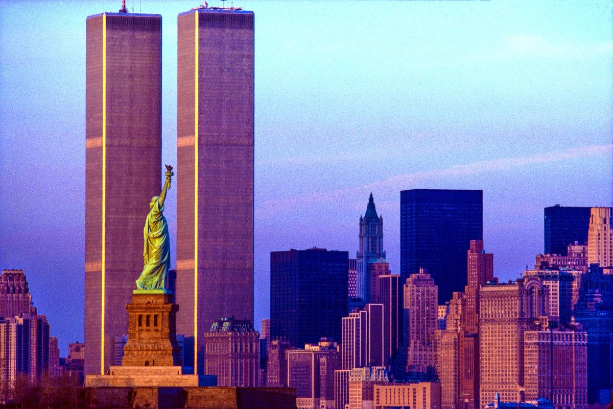 Statue Of Liberty 桌布 壁紙 — 自由女神像在紐約市的暮色天空下，矗立在世界貿易中心的雙子塔前面。