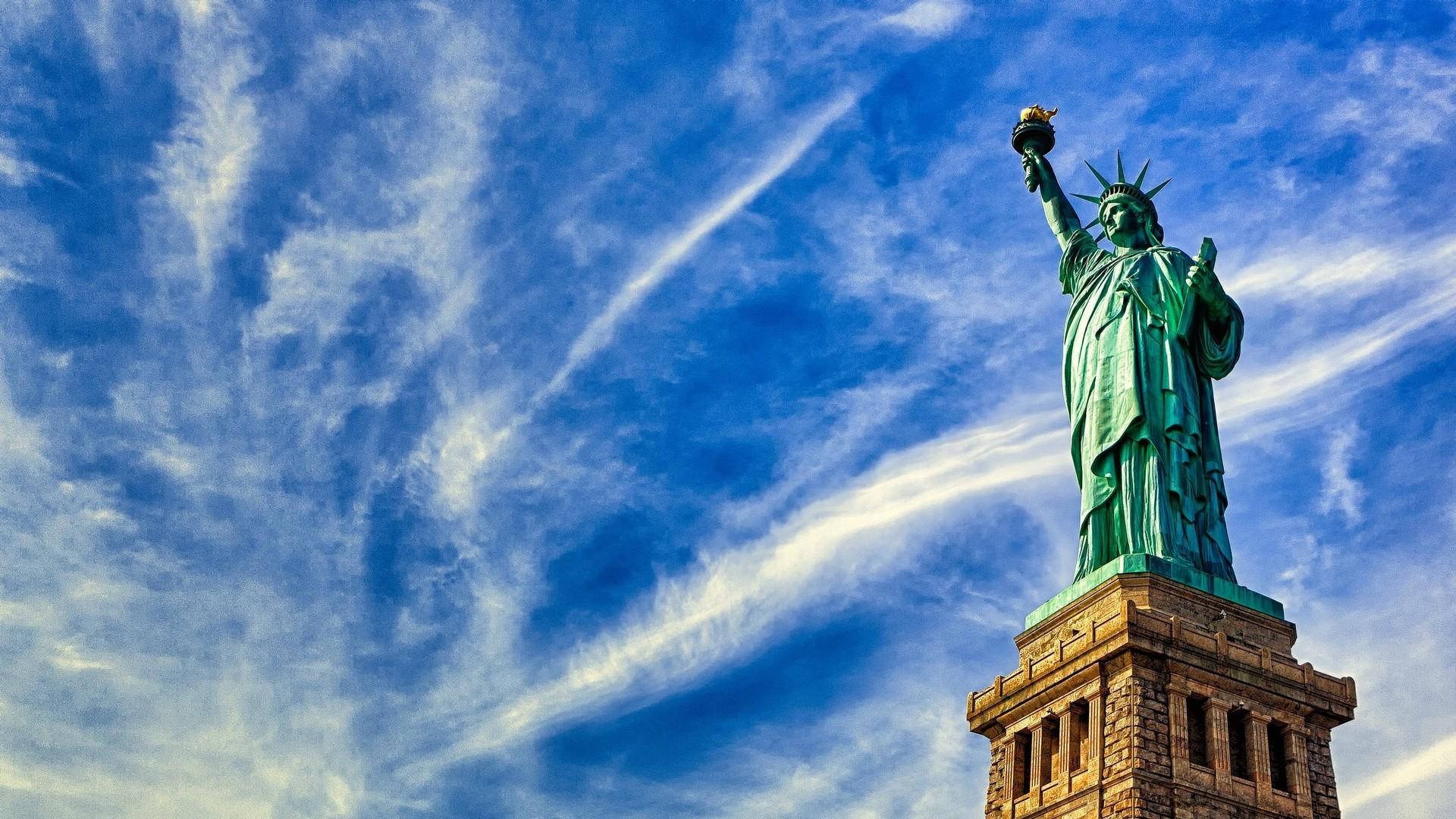 New York 桌布 壁紙 — 自由女神像聳立在藍天白雲下，天空帶有縷縷白雲。