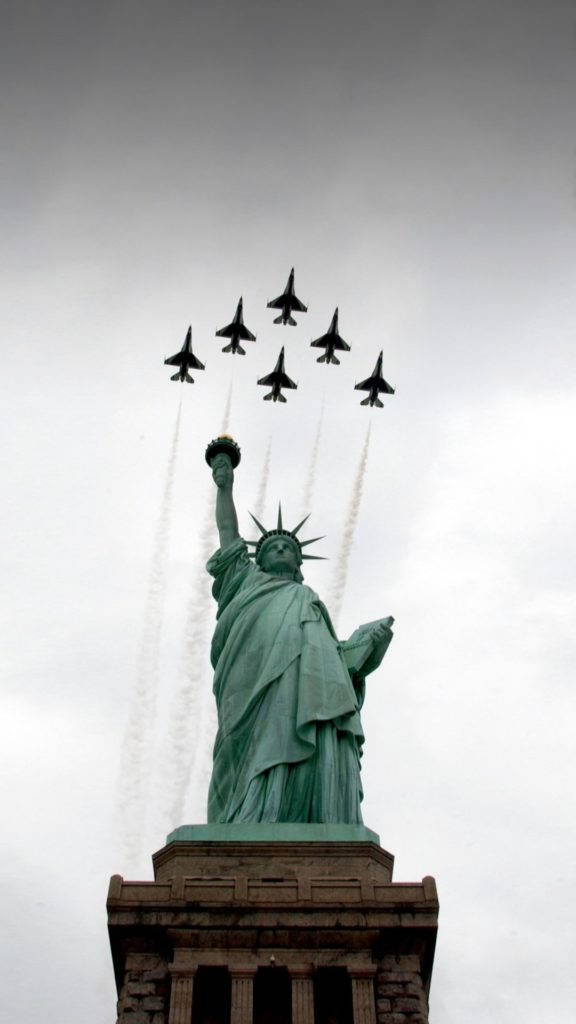Air Force 桌布 壁紙 — 自由女神像高高聳立，六架戰鬥機編隊飛過頭頂，在灰色天空中留下白色煙跡。