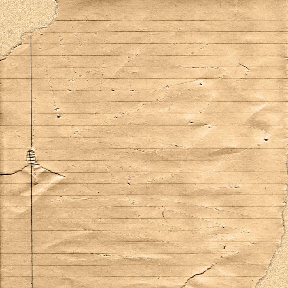 Vintage Paper 桌布 壁紙 — 舊米色橫線筆記本紙張的特寫，邊緣破損，帶有微弱的摺痕，顯示其磨損的質感。
