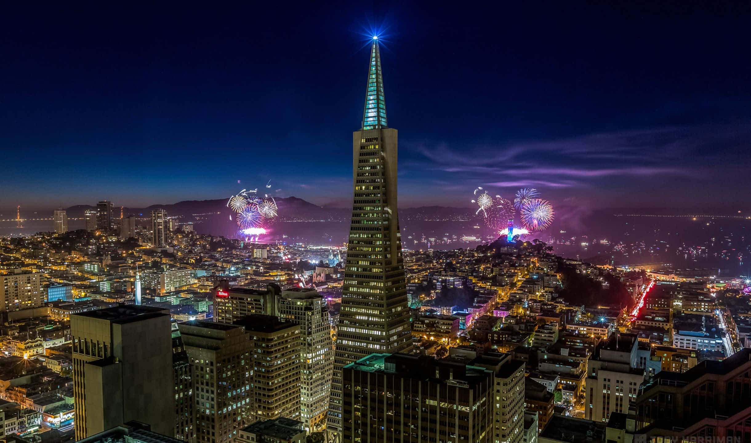 2440x1440 San Francisco 桌布 壁紙 — 舊金山令人目眩的夜景，煙火在標誌性的泛美金字塔和閃爍的天際線上空綻放。