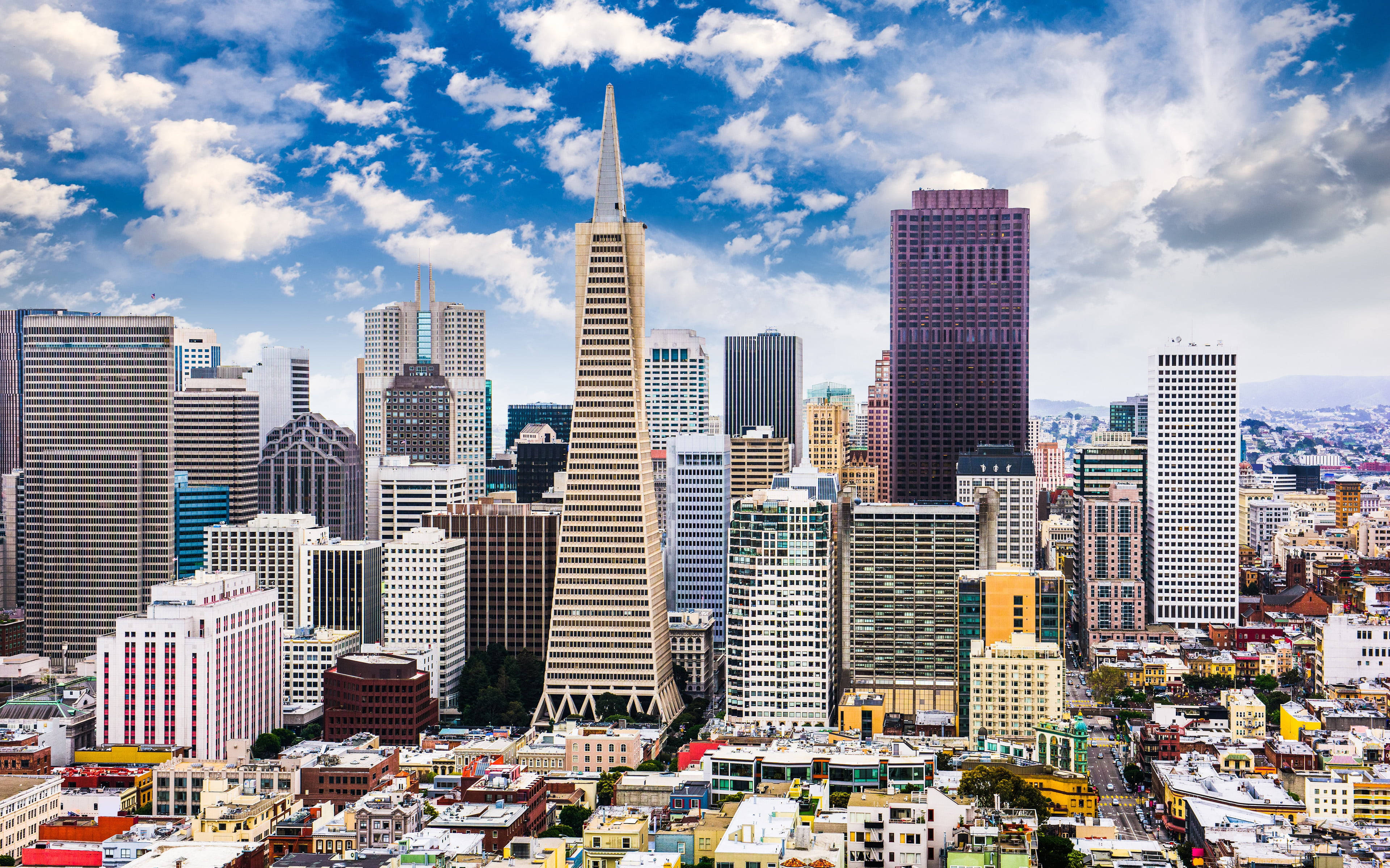 San Francisco Phone 桌布 壁紙 — 舊金山天際線的鳥瞰圖，包括泛美金字塔和摩天大樓，在明亮的藍天和蓬鬆的白雲下。