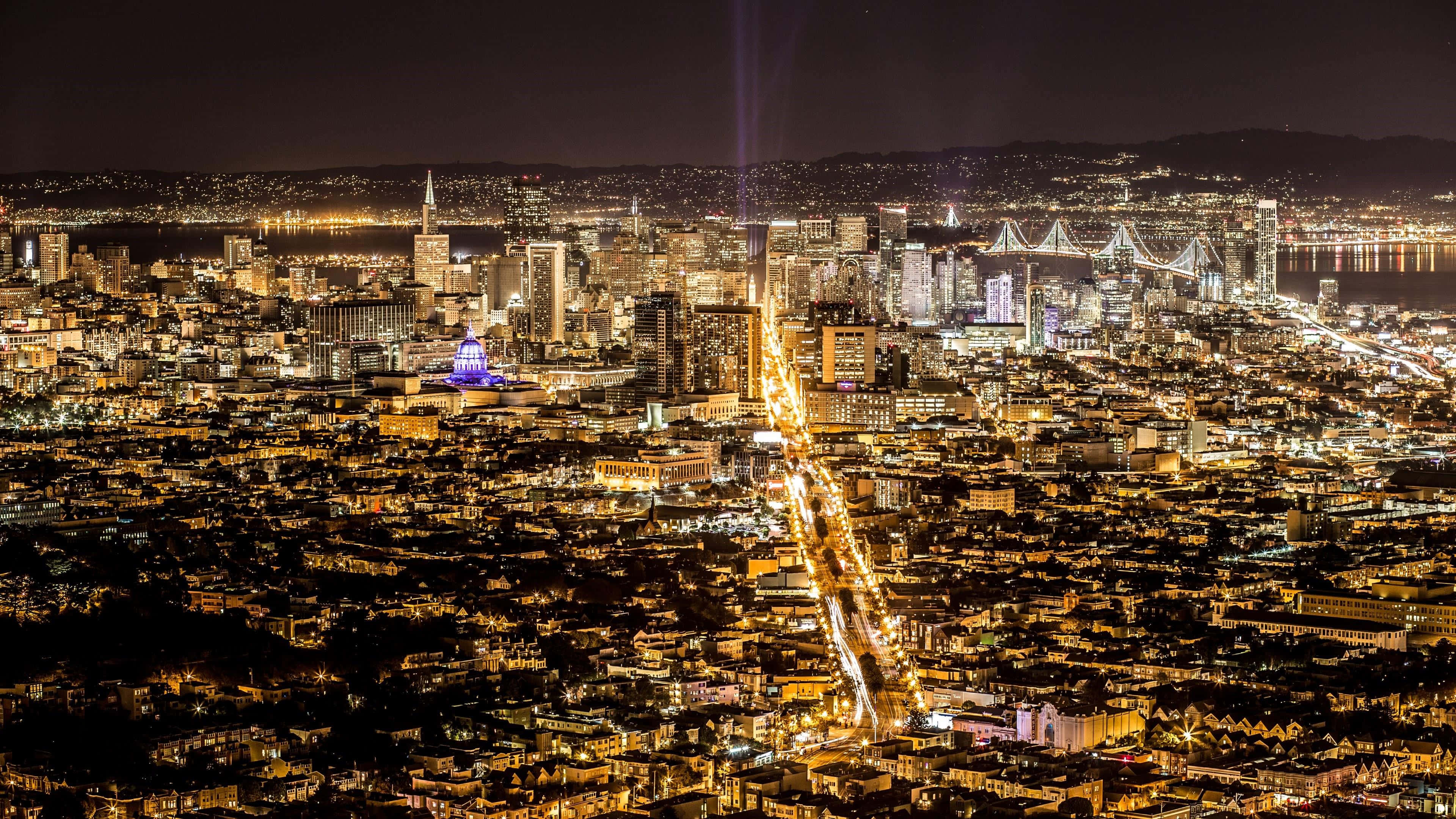 加州 桌布 壁紙 — 舊金山閃爍天際線的夜間空中景觀，金門大橋和城市燈光延伸至山丘。