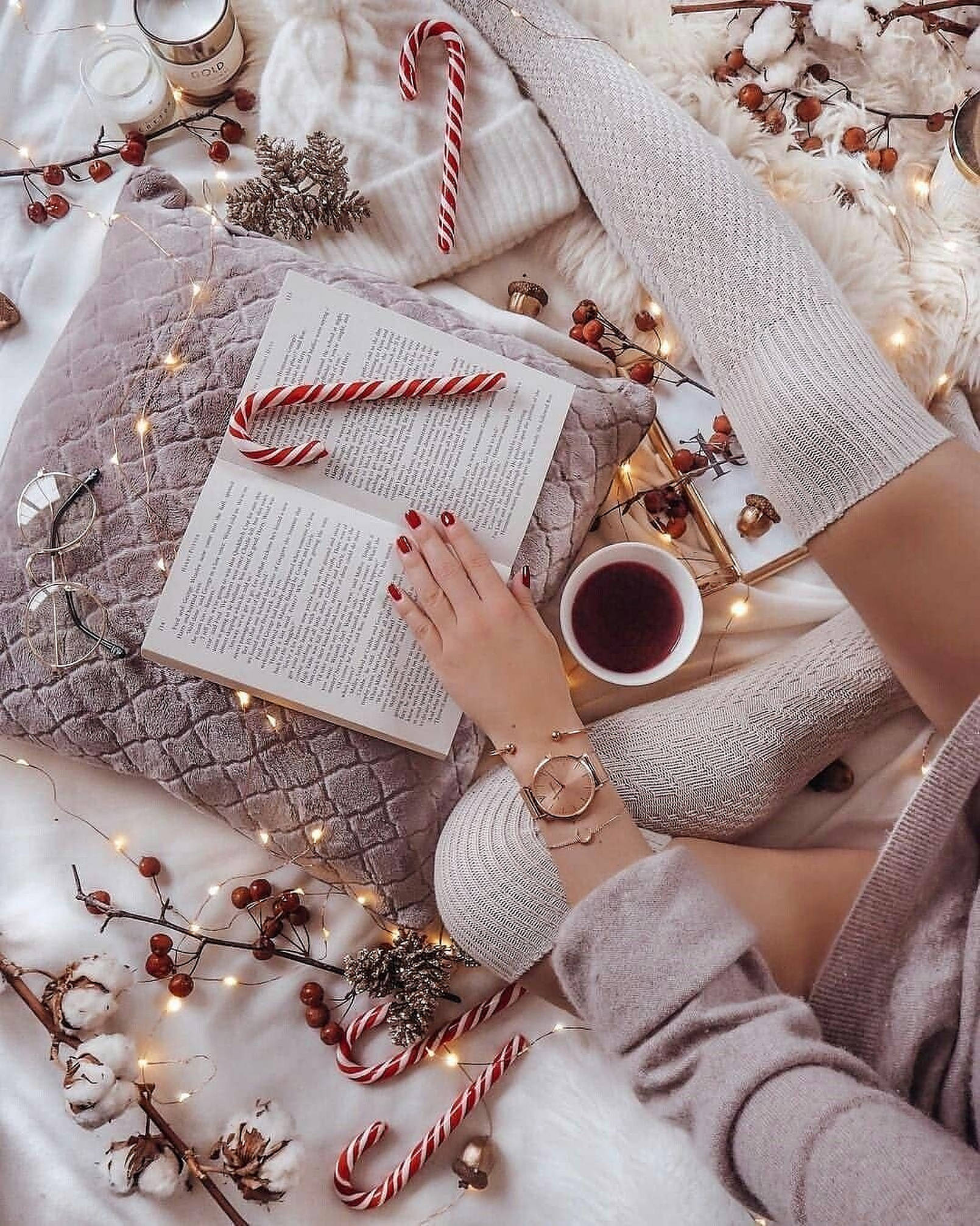 Cozy 桌布 壁紙 — 舒適的冬日場景，一個人正在看書，周圍有拐杖糖、仙女燈和熱飲。