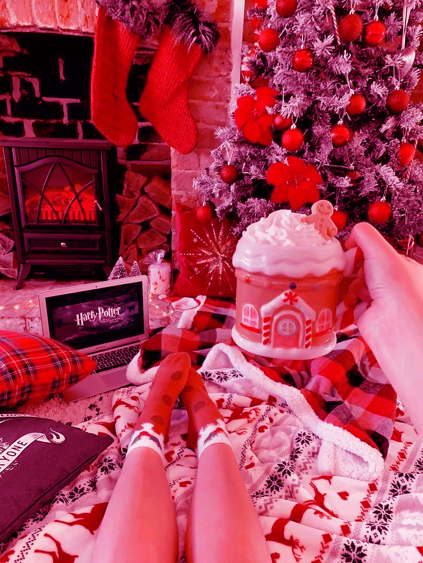 Vintage Christmas 桌布 壁紙 — 舒適的冬日場景，穿著圖案襪子的腳擱在壁爐和裝飾樹附近的毯子上。