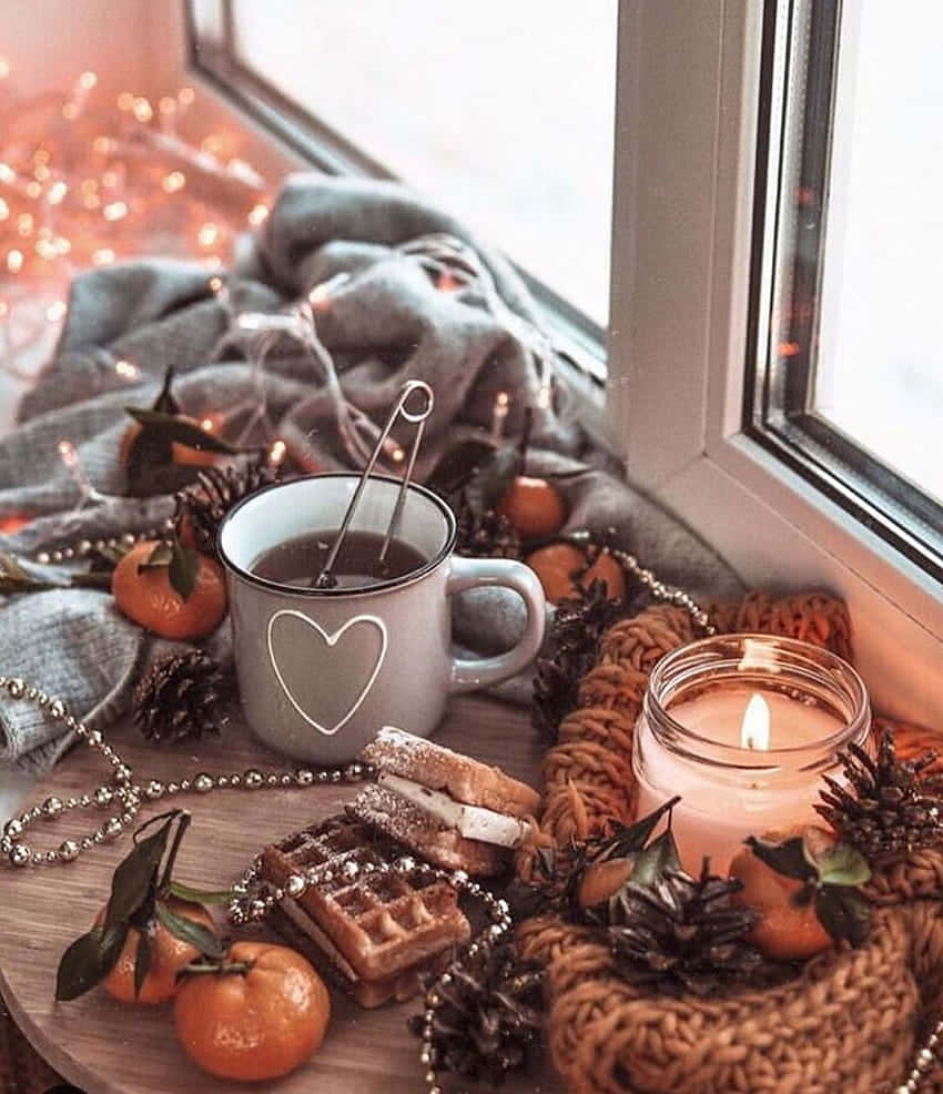 Cozy Winter Desktop 桌布 壁紙 — 舒適的冬日窗台，配有熱飲、蠟燭、松果、柑橘、發光燈串和柔軟的針織毯。