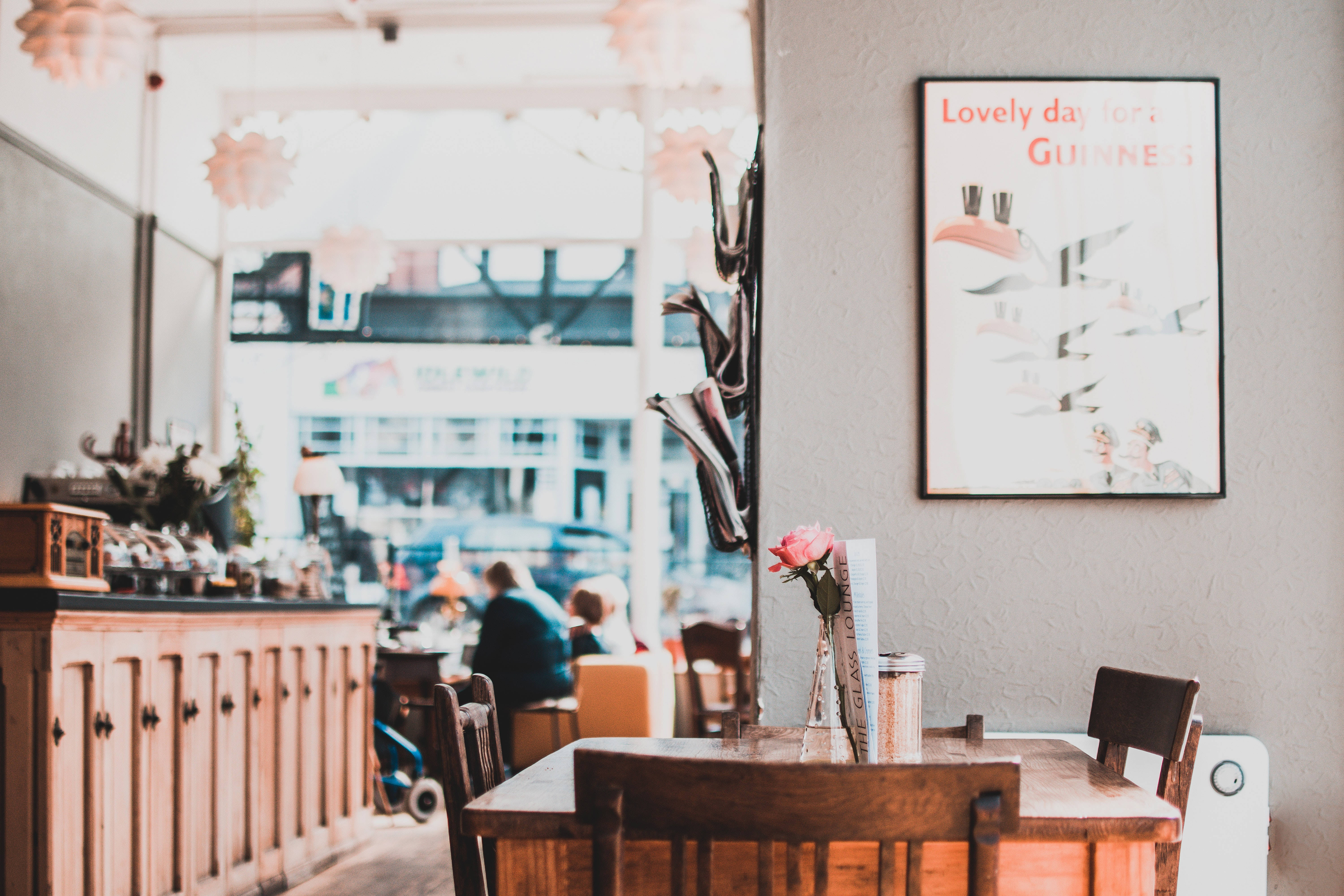 Coffee Shop 桌布 壁紙 — 舒適的咖啡館內部，配有木製桌椅和牆上的復古健力士海報。
