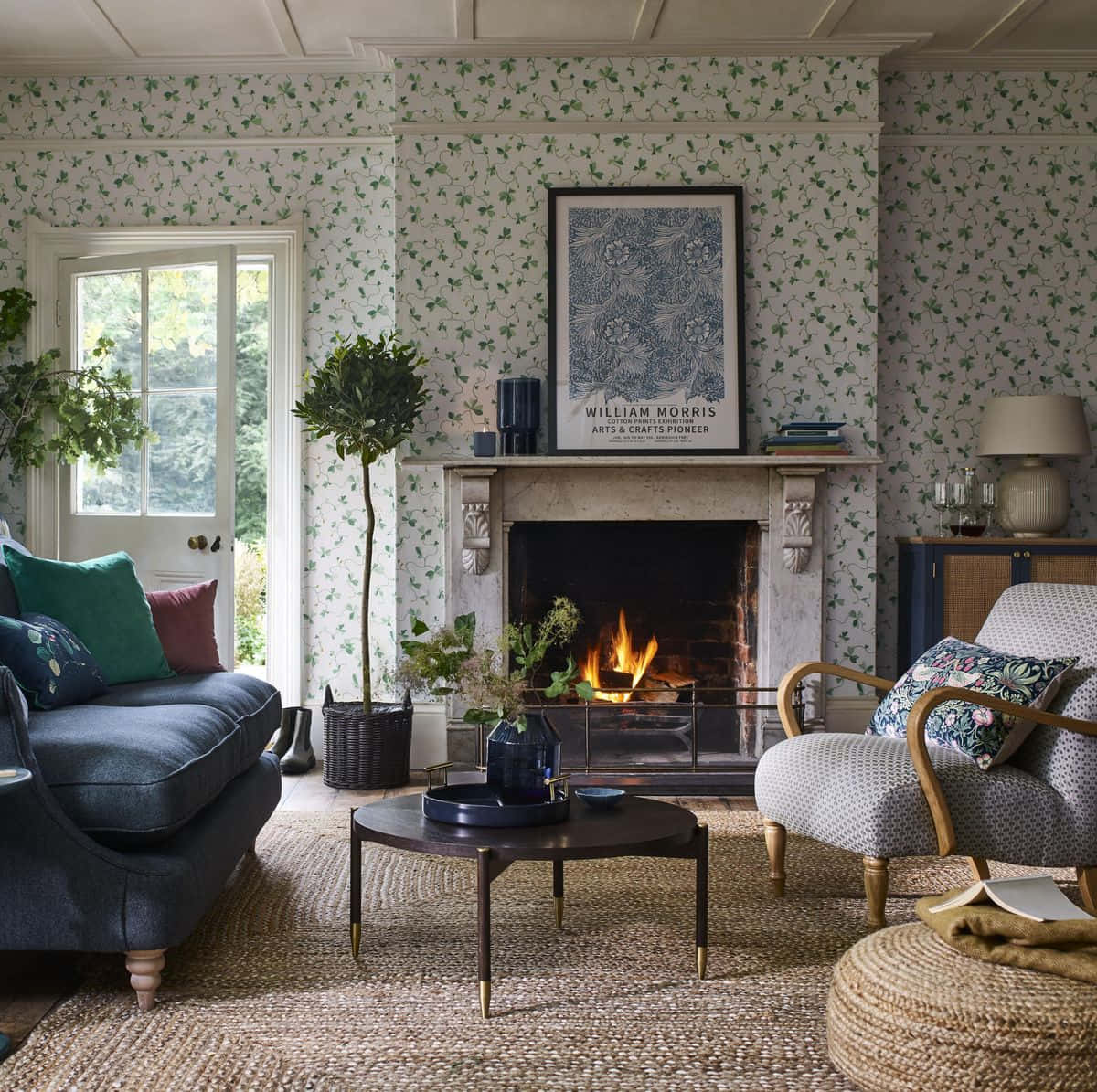 Autumn Fireplace 桌布 壁紙 — 舒適的客廳，配有綠色常春藤壁紙、壁爐和藍色沙發，沐浴在自然光中。