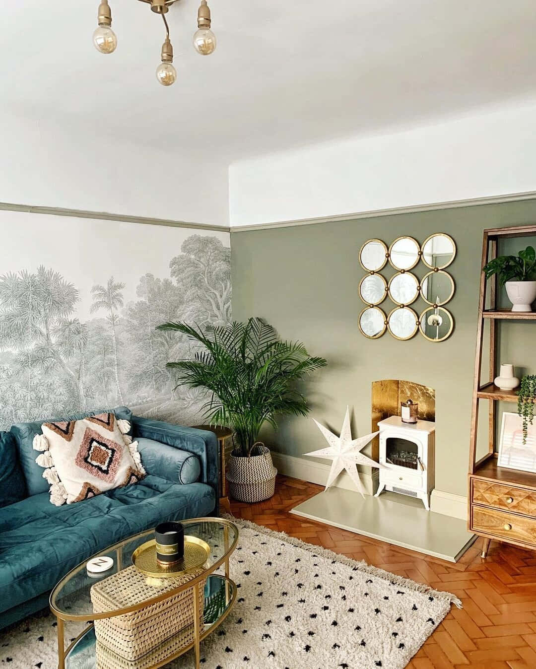 Living Room 桌布 壁紙 — 舒適的客廳，配有藍綠色天鵝絨沙發、棕櫚樹壁紙、金色裝飾和木質人字形地板。