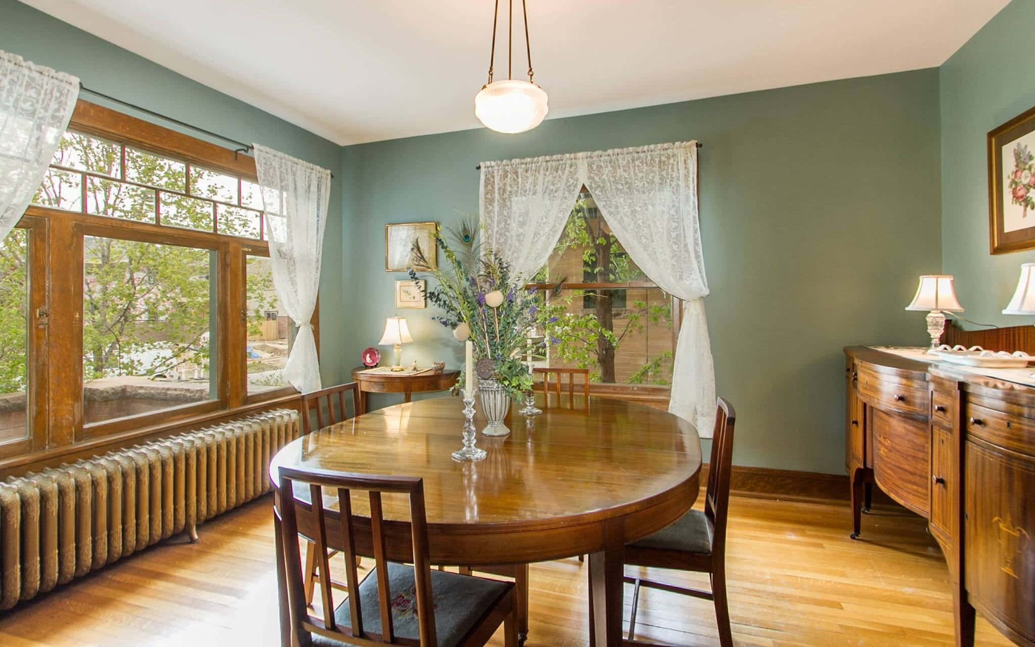 Dining Room 桌布 壁紙 — 舒適的復古餐廳，配有木製家具、綠色牆壁、蕾絲窗簾，以及大窗戶透進的自然光。