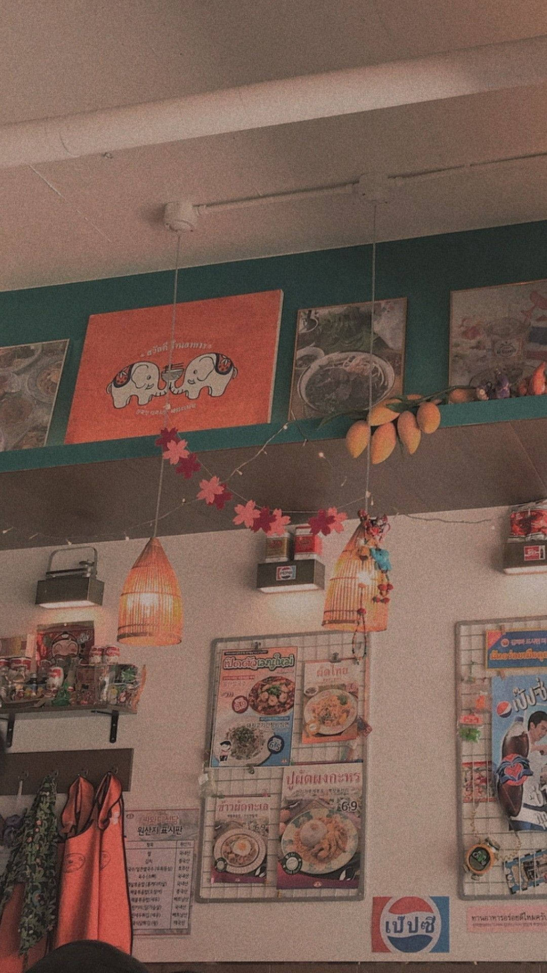 Interior Design 桌布 壁紙 — 舒適的泰式餐廳內部，掛有燈籠、菜單板和裝飾芒果，在溫暖的燈光下。