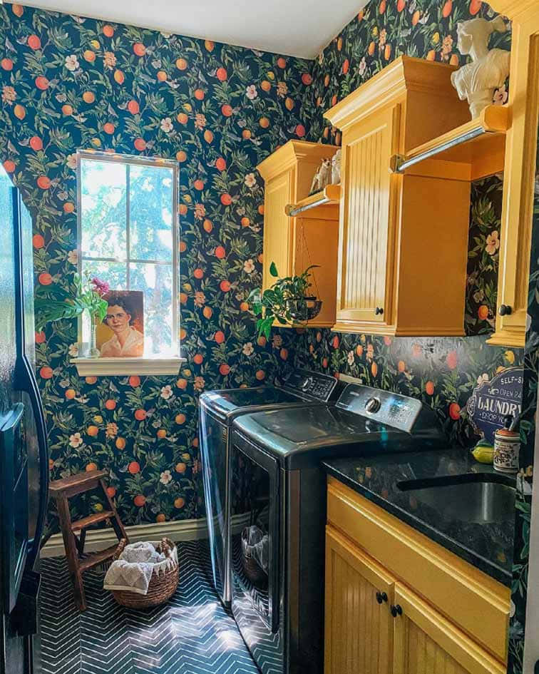 kitchen 桌布 壁紙 — 舒適的洗衣房，配有深色花卉壁紙、黃色櫥櫃和讓自然光線進入的窗戶。
