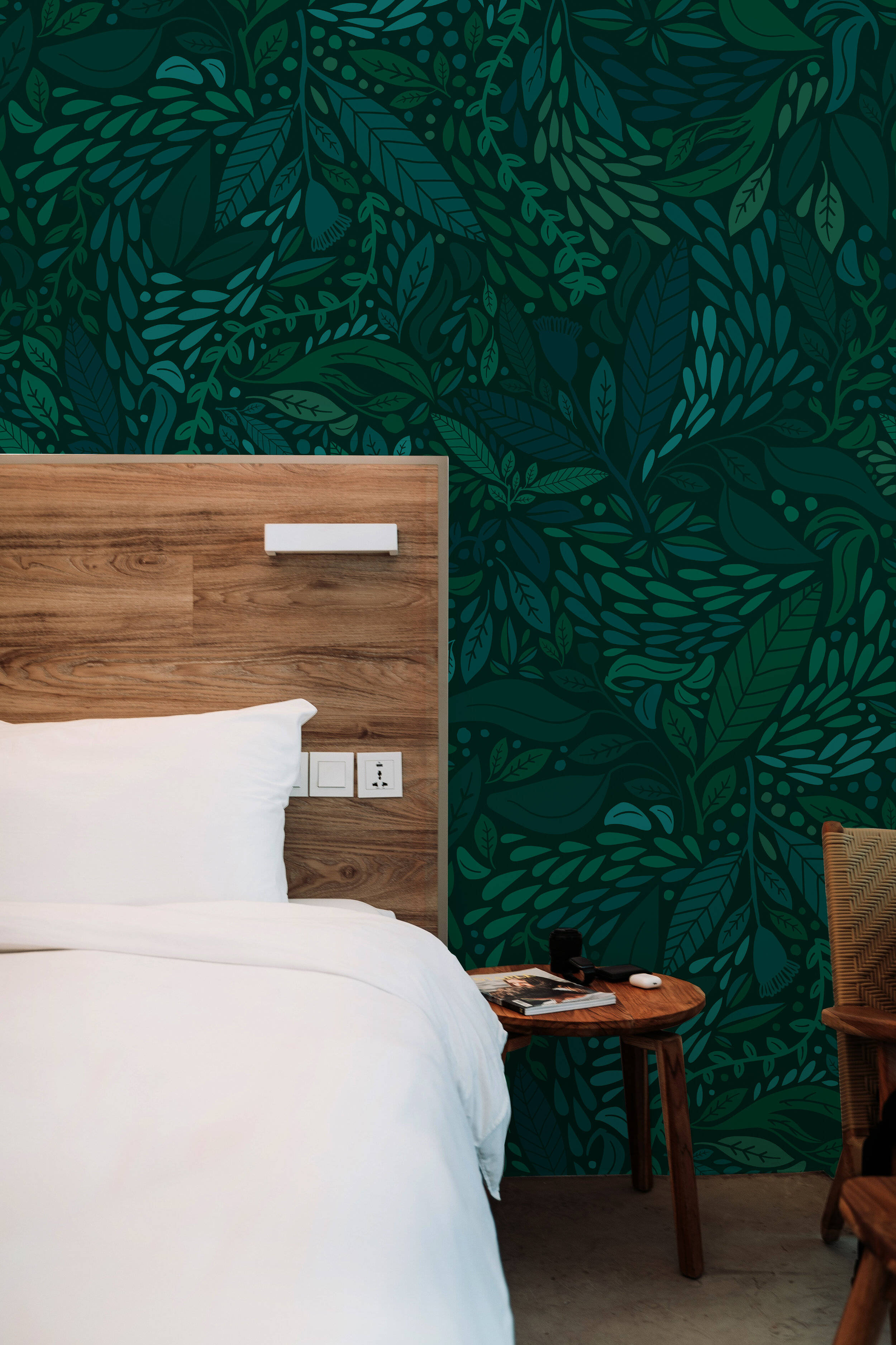Bedroom 桌布 壁紙 — 舒適的臥室，配有一張木床，背景是充滿活力的綠色葉子圖案壁紙，還有一張小木邊桌。