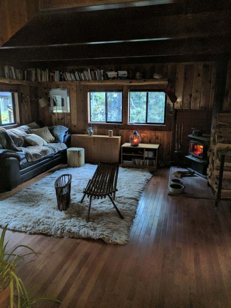 cabin 桌布 壁紙 — 舒適質樸的小木屋客廳，配有木牆、壁爐和溫暖環境照明下的毛絨地毯。
