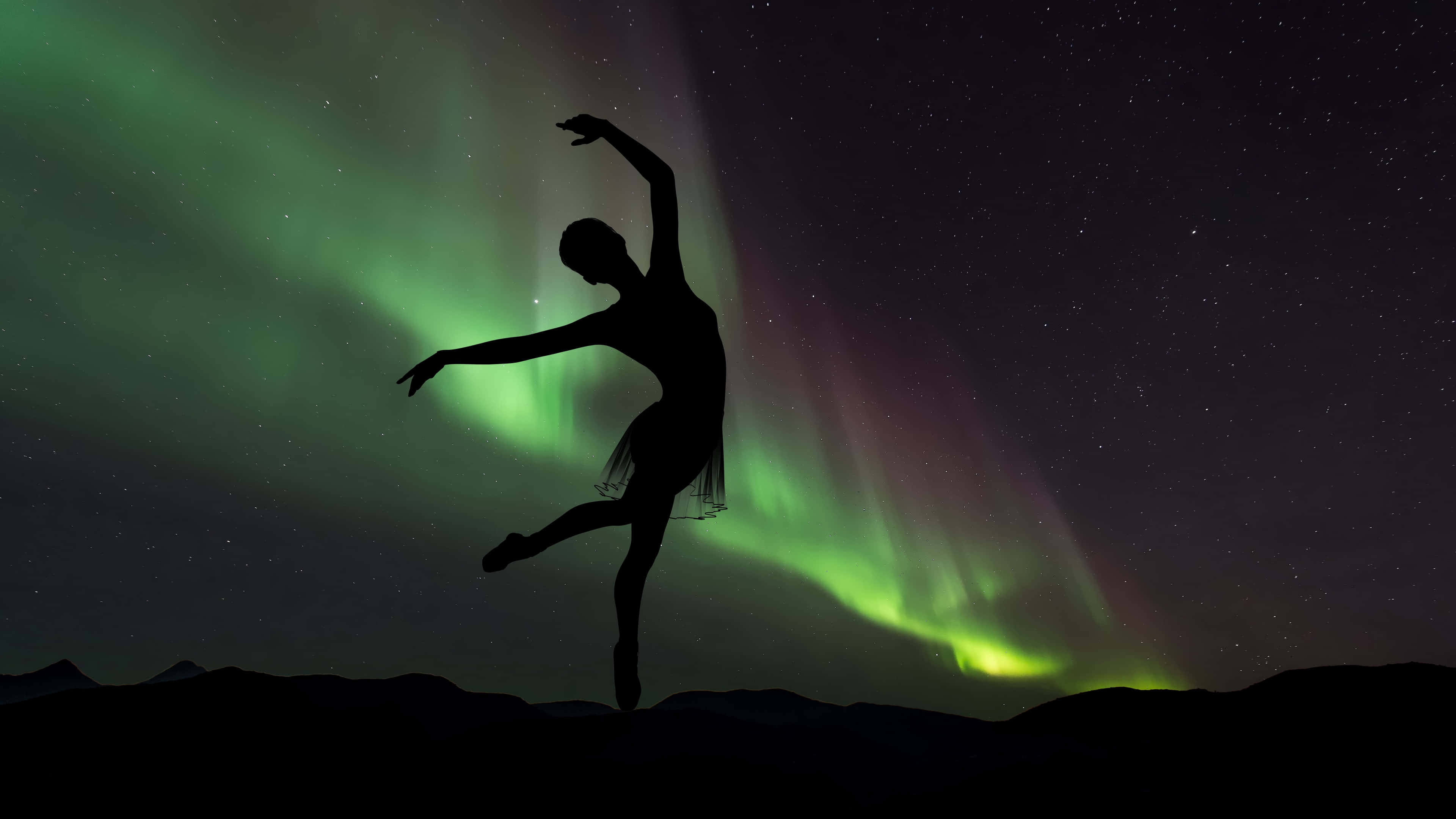 Ballet 桌布 壁紙 — 舞者的剪影在星空下優雅地躍起，背景是充滿活力的綠色和紫色極光。