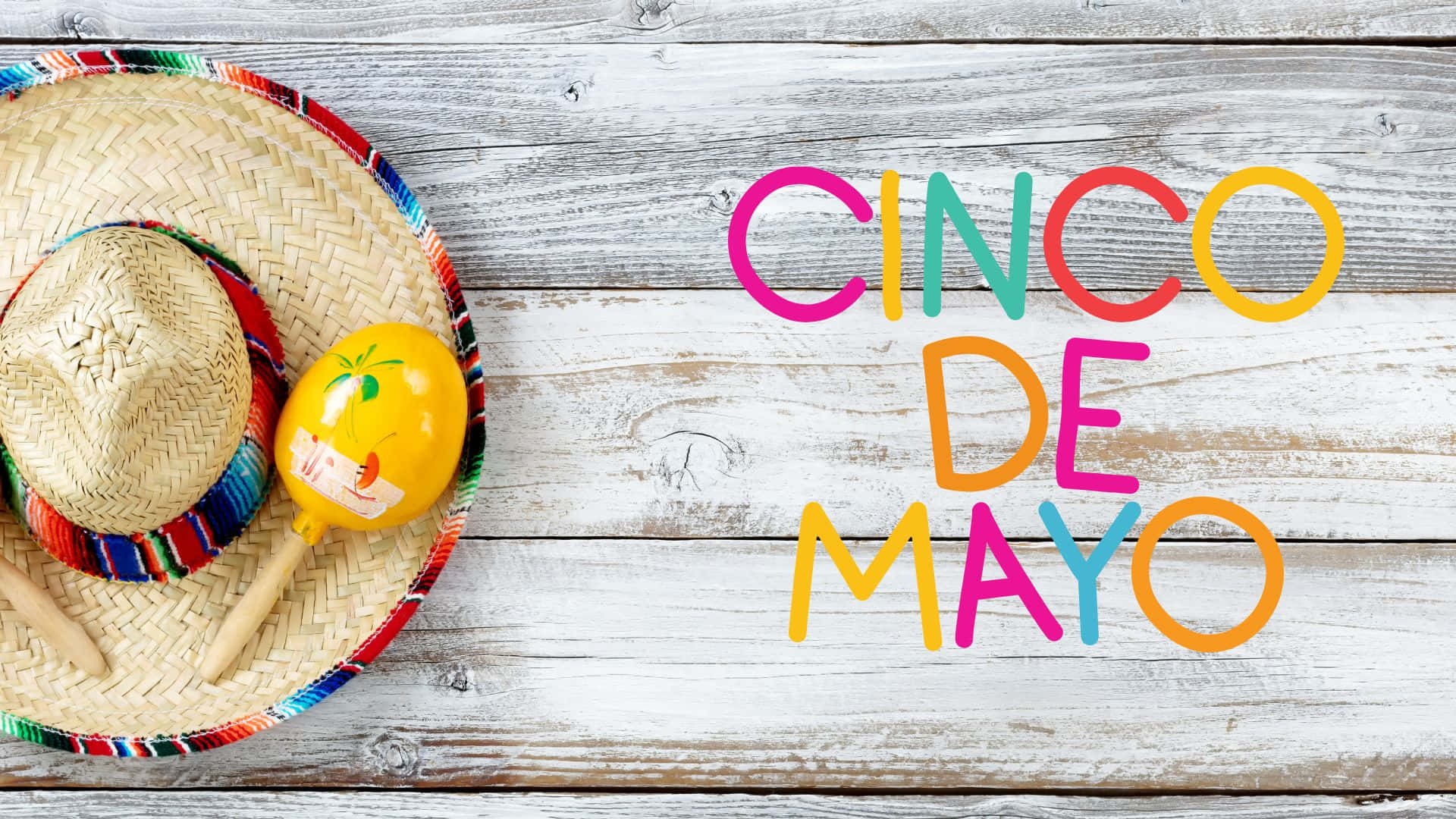 Cinco De Mayo 桌布 壁紙 — 色彩繽紛的 Cinco de Mayo 文字和節日墨西哥帽及沙鈴在風化木板上。