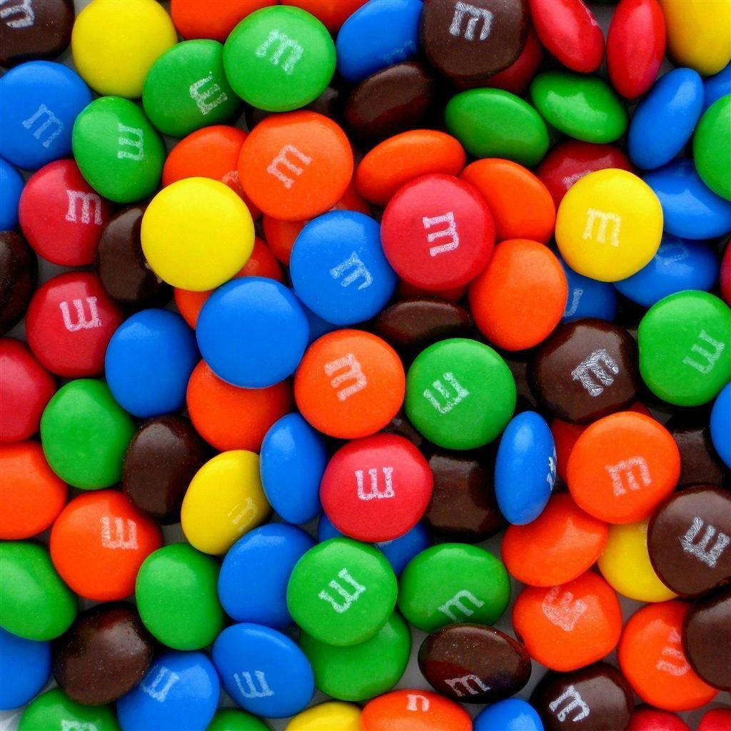 Chocolate 桌布 壁紙 — 色彩繽紛的M&M's糖果特寫，白色「m」標誌密集散落。