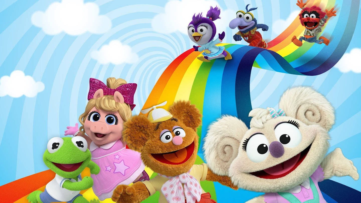 babies 桌布 壁紙 — 色彩繽紛的Muppet角色在明亮的藍天和蓬鬆雲朵背景下，歡樂地騎著鮮豔的彩虹。