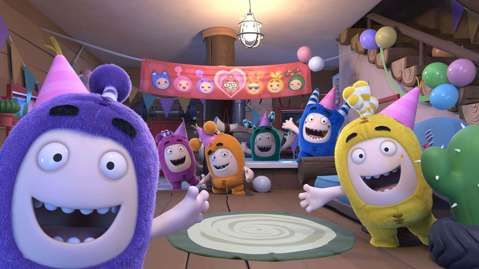 Oddbods 桌布 壁紙 — 色彩繽紛的卡通怪物戴著派對帽，在裝飾著氣球和橫幅的木屋內快樂地慶祝。