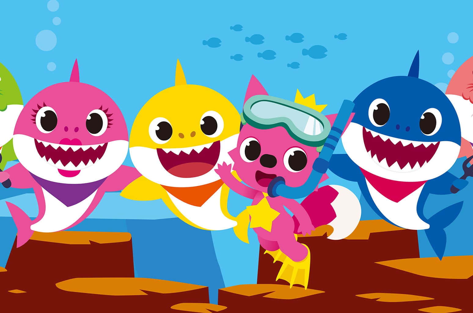 baby shark 桌布 壁紙 — 色彩繽紛的卡通鯊魚和一隻粉紅色貓潛水員，在陽光照射的水下礁石中快樂地探索，伴隨著氣泡和小魚。