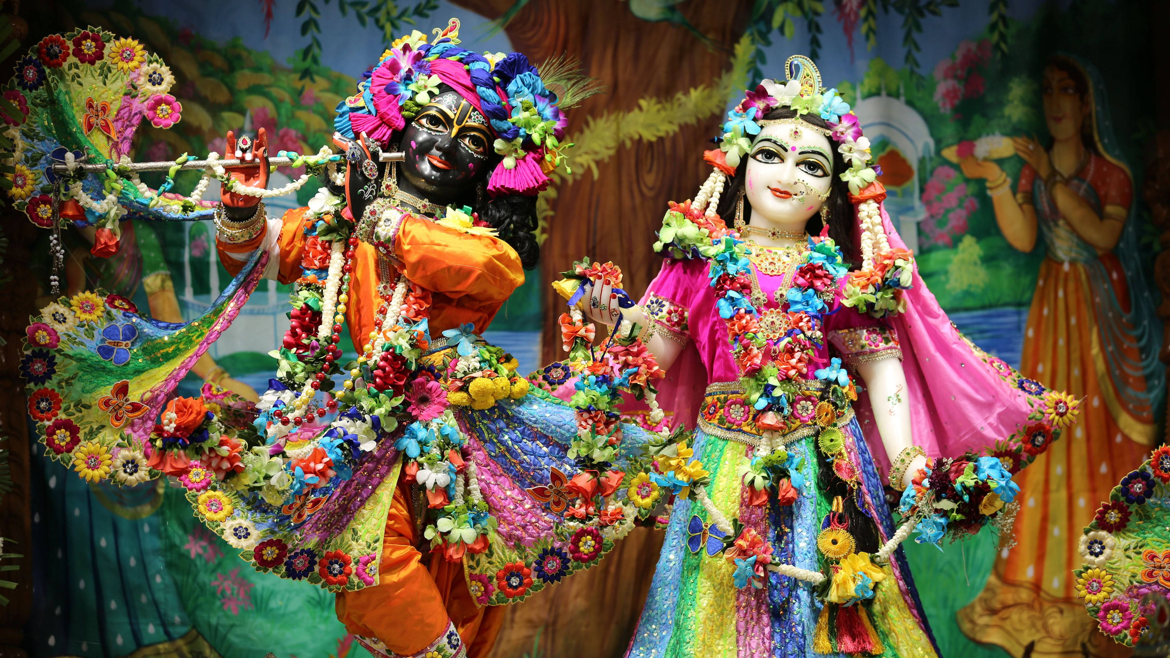 krishna ji 桌布 壁紙 — 色彩繽紛的印度教神祇克里希納和拉達，裝飾著鮮豔的花環和充滿活力的傳統服飾。