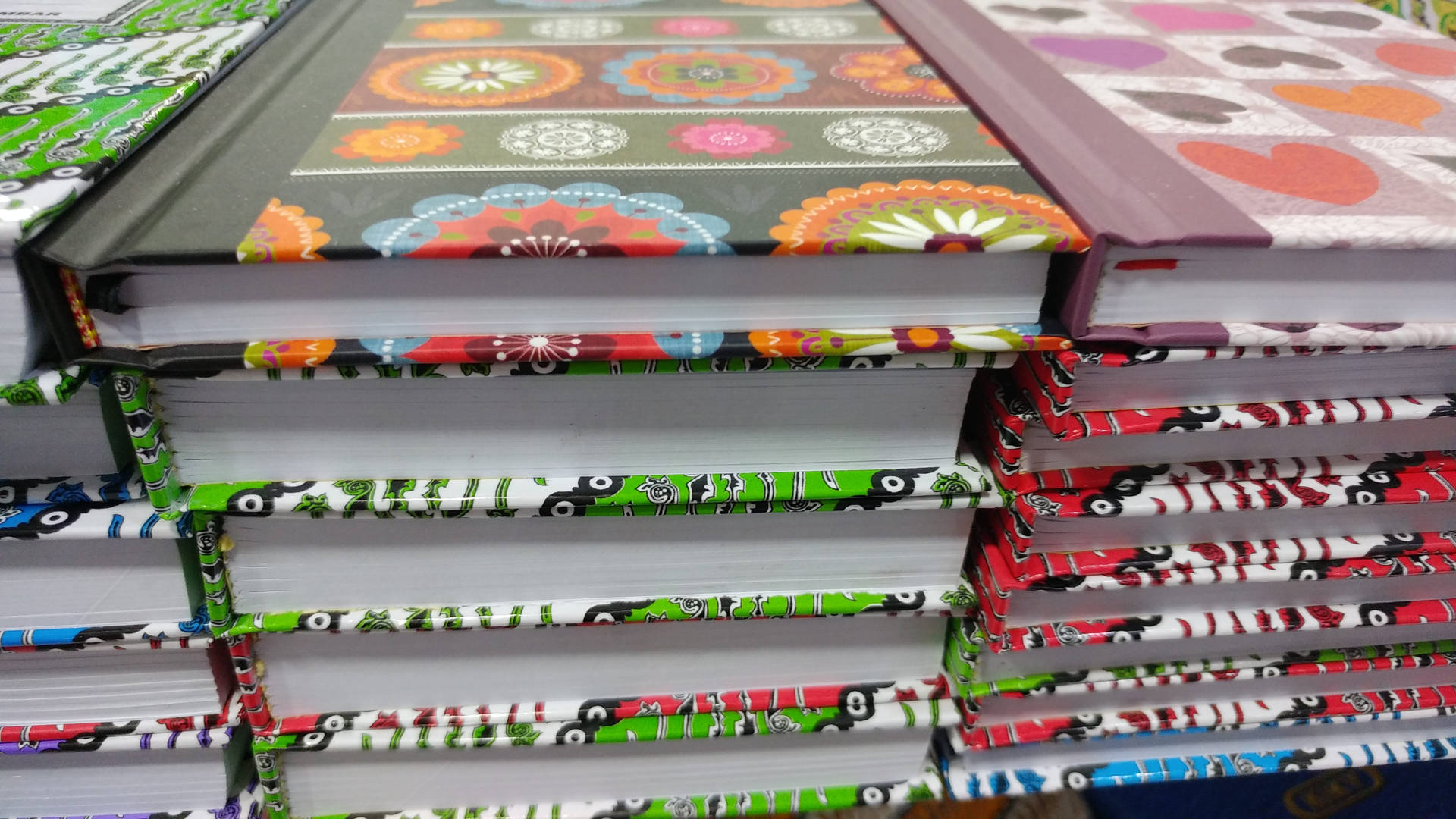 堆疊的書籍，帶有色彩繽紛的圖案封面和書脊。