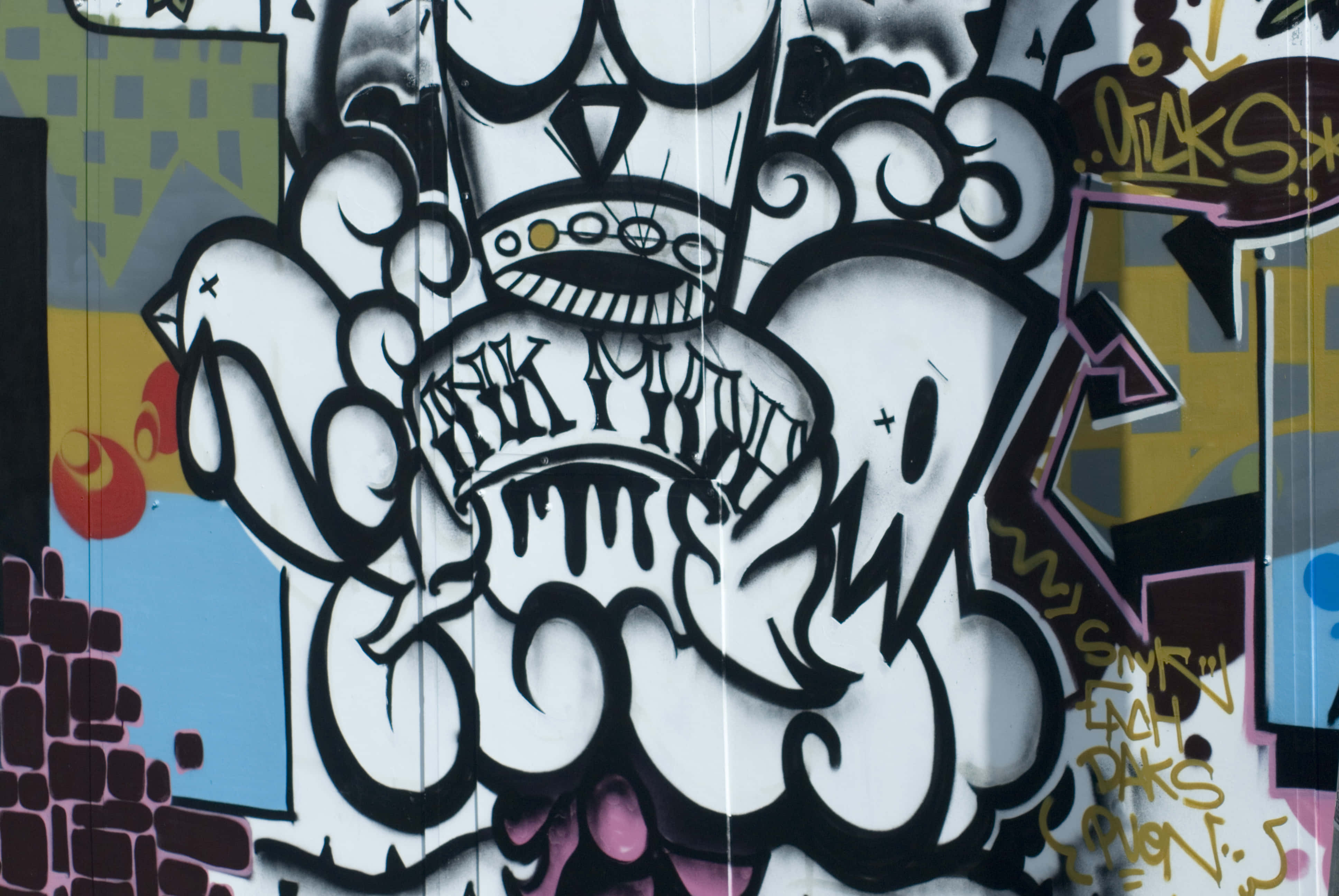 Black And White Graffiti 桌布 壁紙 — 色彩繽紛的城市牆上，帶有皇冠頭骨和漩渦雲朵的大膽黑白塗鴉藝術。