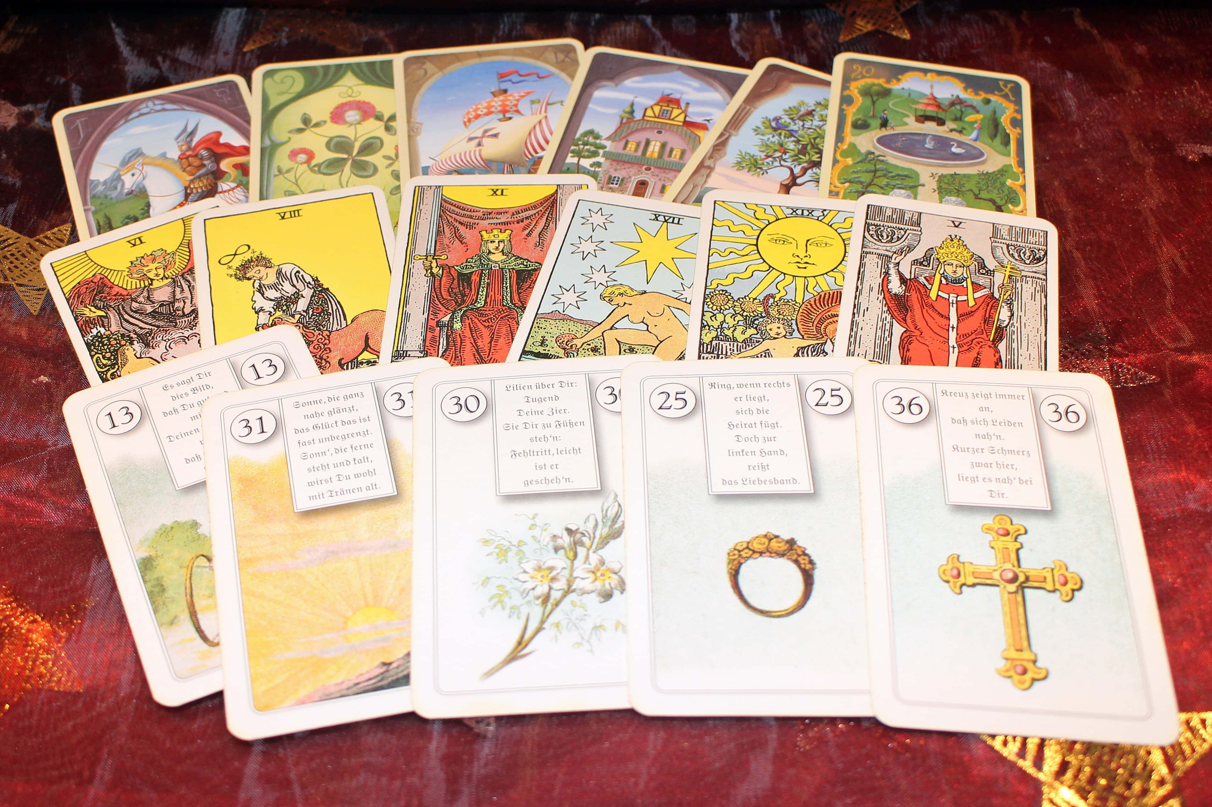 Fortune Teller 桌布 壁紙 — 色彩繽紛的塔羅牌，帶有德語文字和象徵性圖案，鋪陳在華麗的紅色天鵝絨表面上。