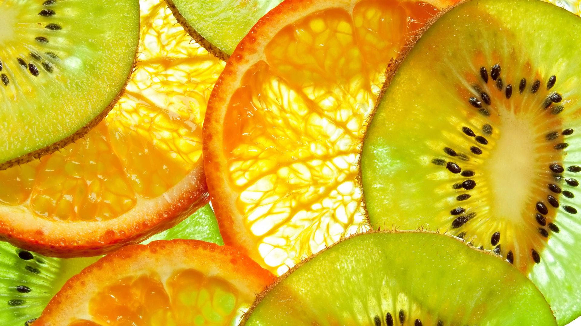 Orange Fruit 桌布 壁紙 — 色彩繽紛的多汁奇異果和柳橙片重疊排列的鮮明特寫。