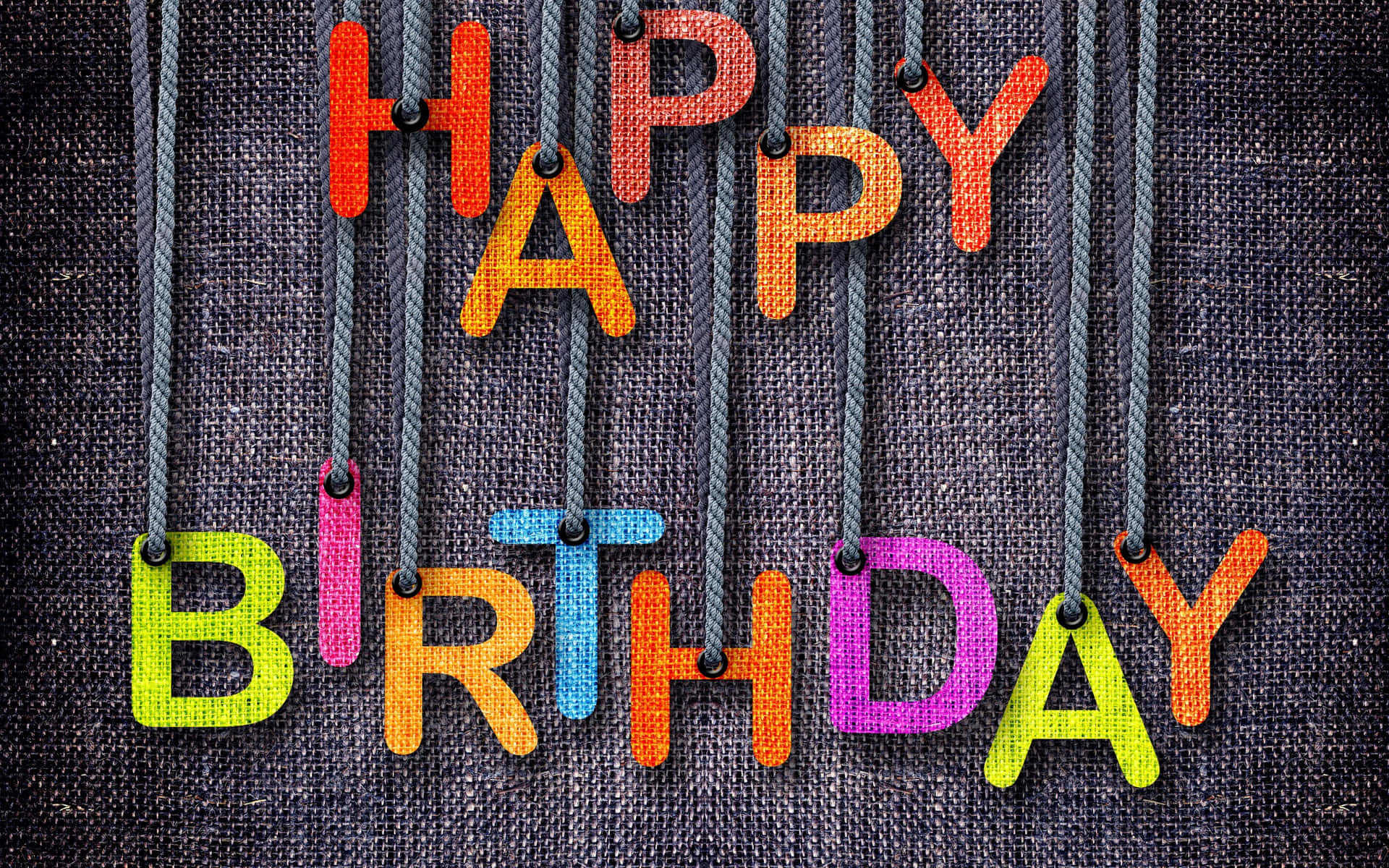 生日快樂 桌布 壁紙 — 色彩繽紛的布料字母拼出 happy birthday，掛在繩子上，背景為深色紋理。