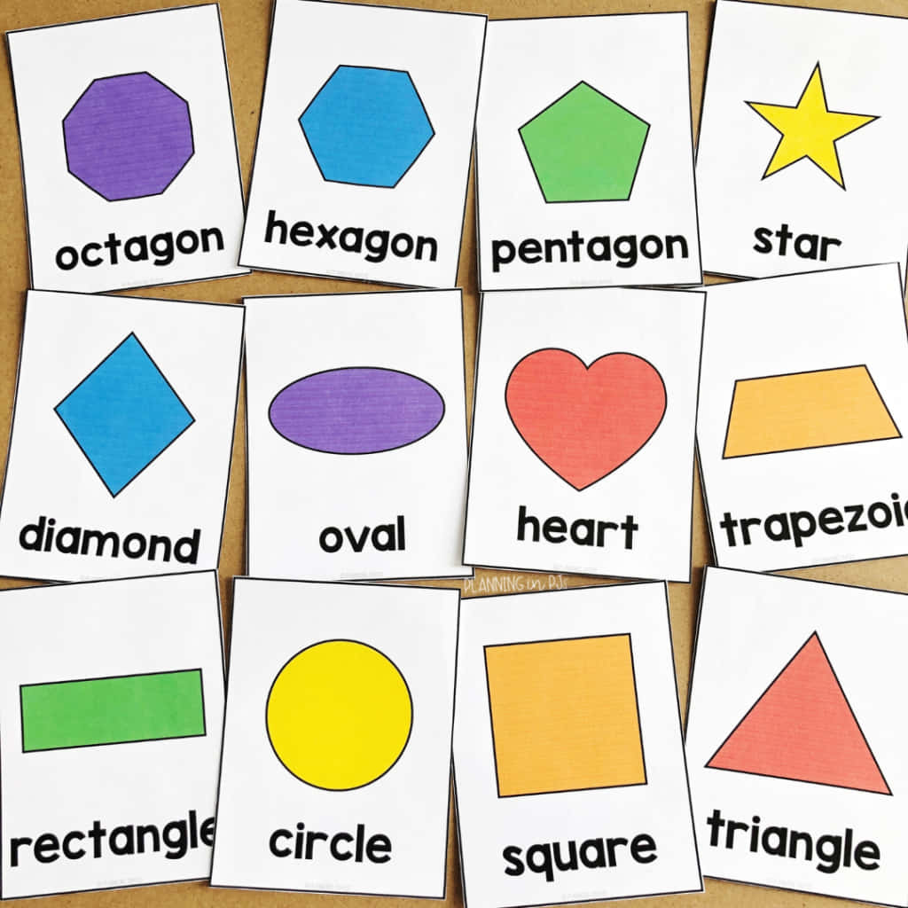 Shapes 桌布 壁紙 — 色彩繽紛的幾何形狀閃卡，上面標有名稱，擺放在棕色紙張背景上。