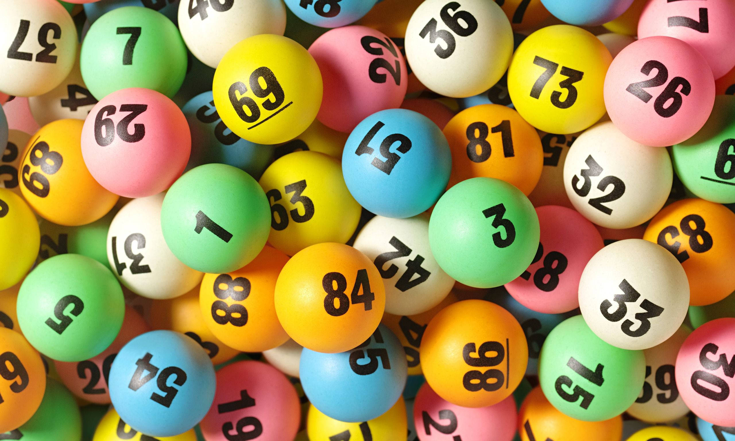 Lottery 桌布 壁紙 — 色彩繽紛的彩票球特寫，粗體黑色數字密集散落。