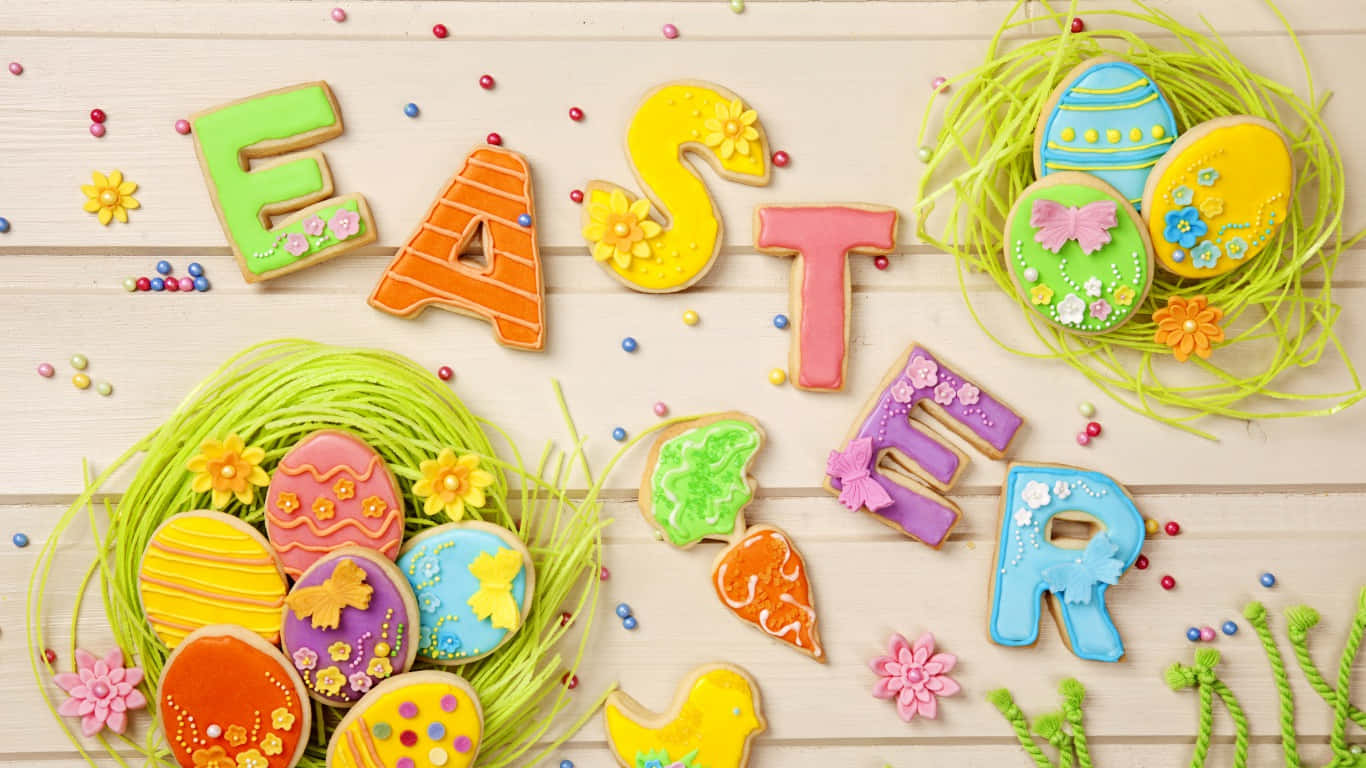 Cute Happy Easter 桌布 壁紙 — 色彩繽紛的復活節餅乾，造型為字母和雞蛋，放置在木質表面的綠色草地上。