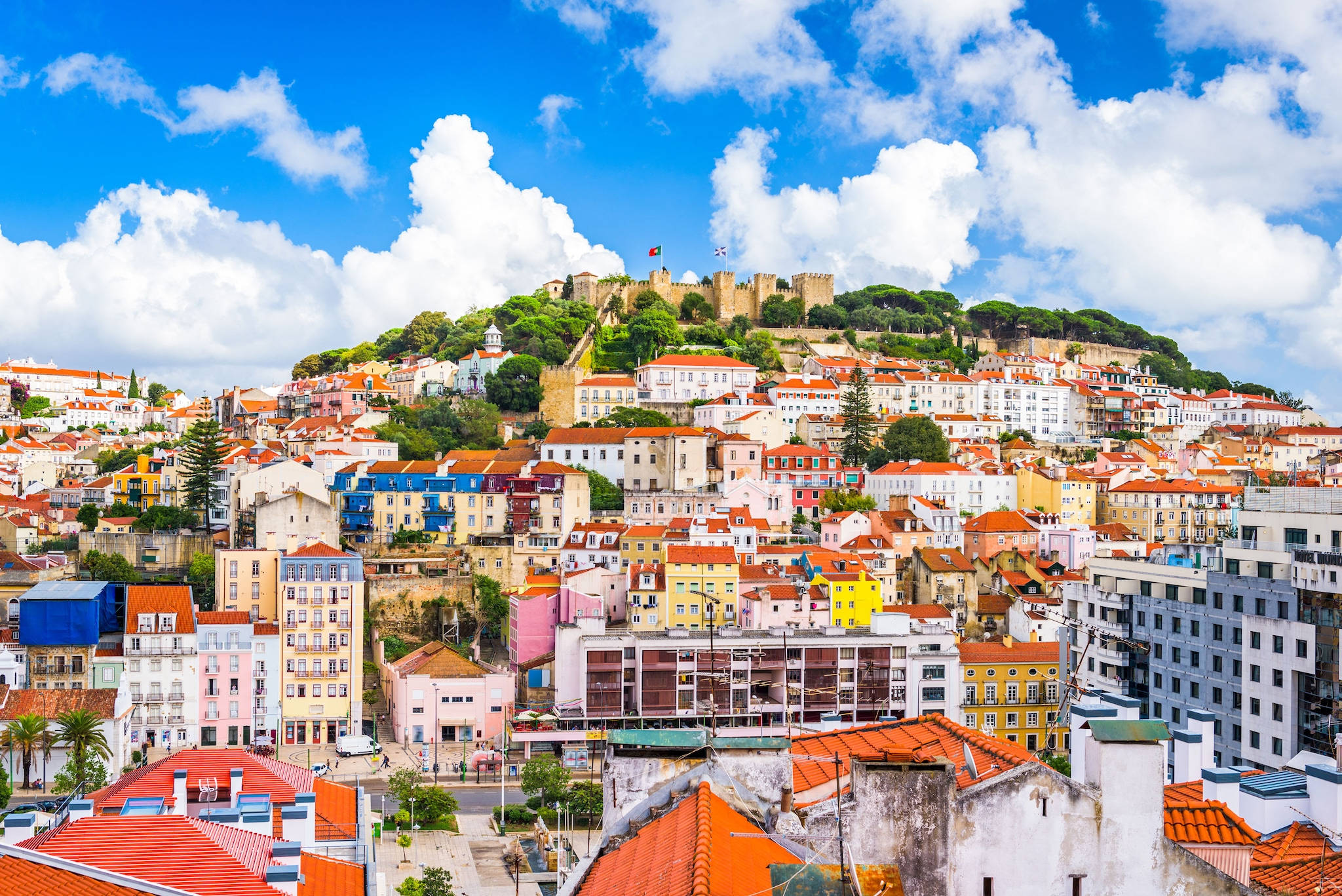 Portugal 桌布 壁紙 — 色彩繽紛的房屋，紅色屋頂，沿著山坡層疊而下，在明亮的藍天下，有蓬鬆的白雲。