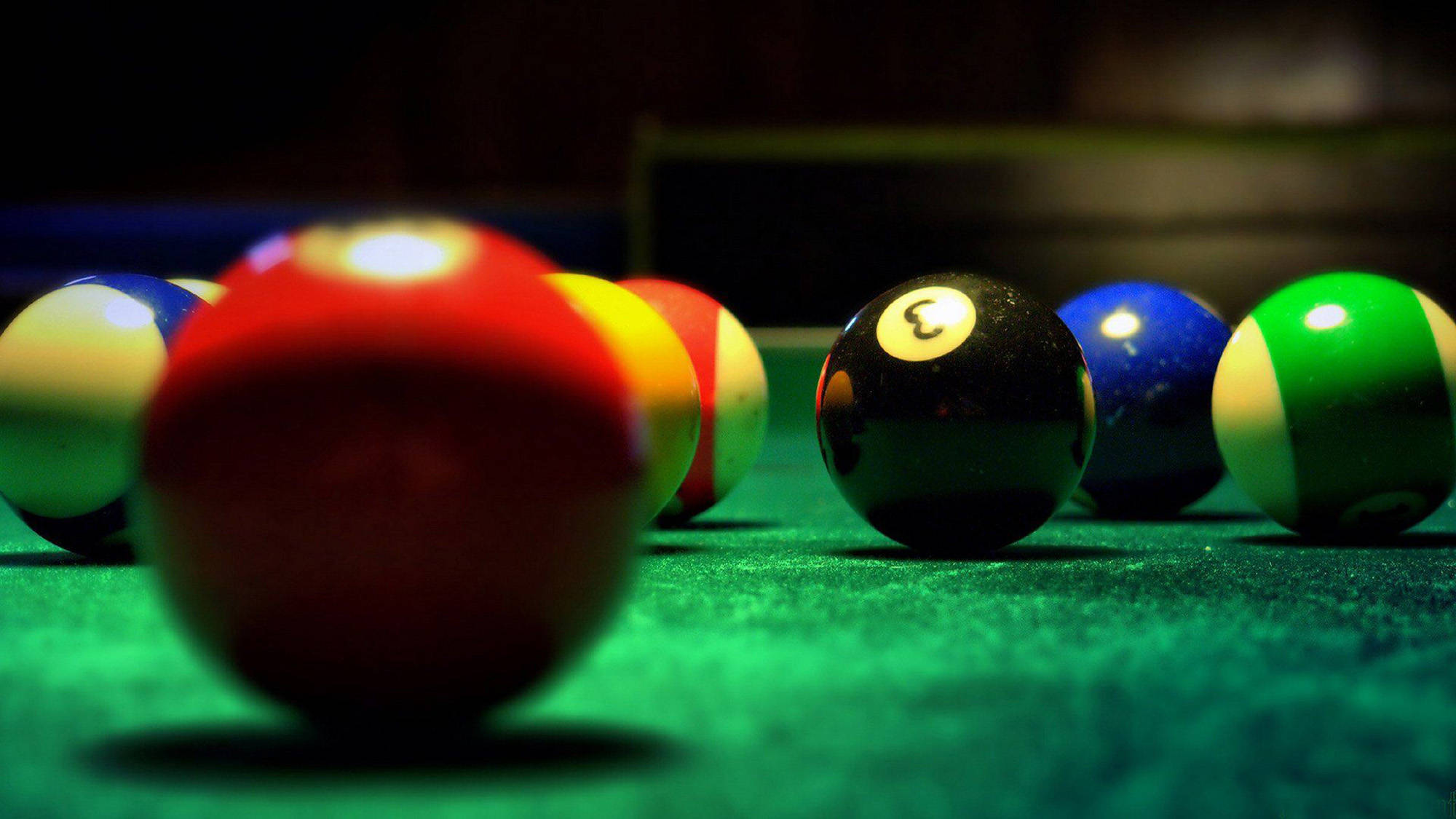 Snooker 桌布 壁紙 — 色彩繽紛的撞球在綠色絨布桌上的特寫，淺景深與溫暖燈光。