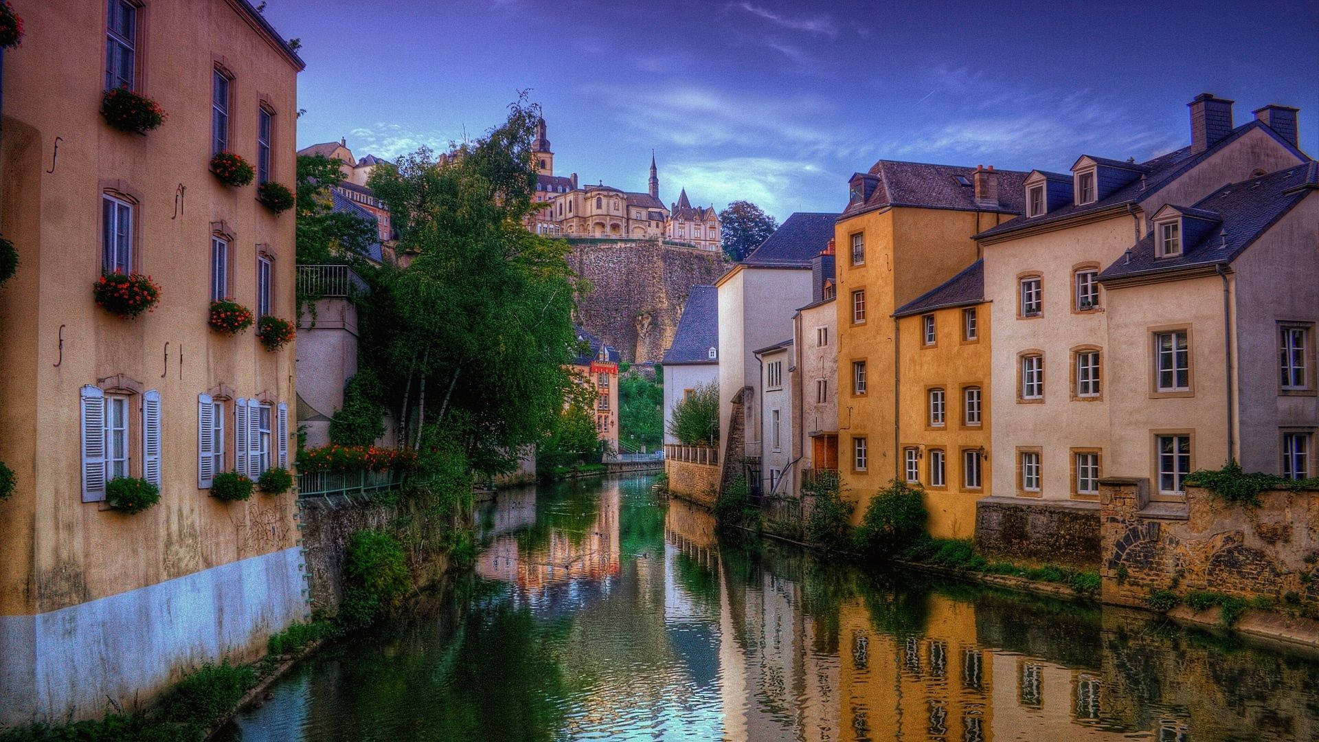 Luxembourg 桌布 壁紙 — 色彩繽紛的歷史建築沿著平靜的運河排列，在暮色天空下倒映著城堡。