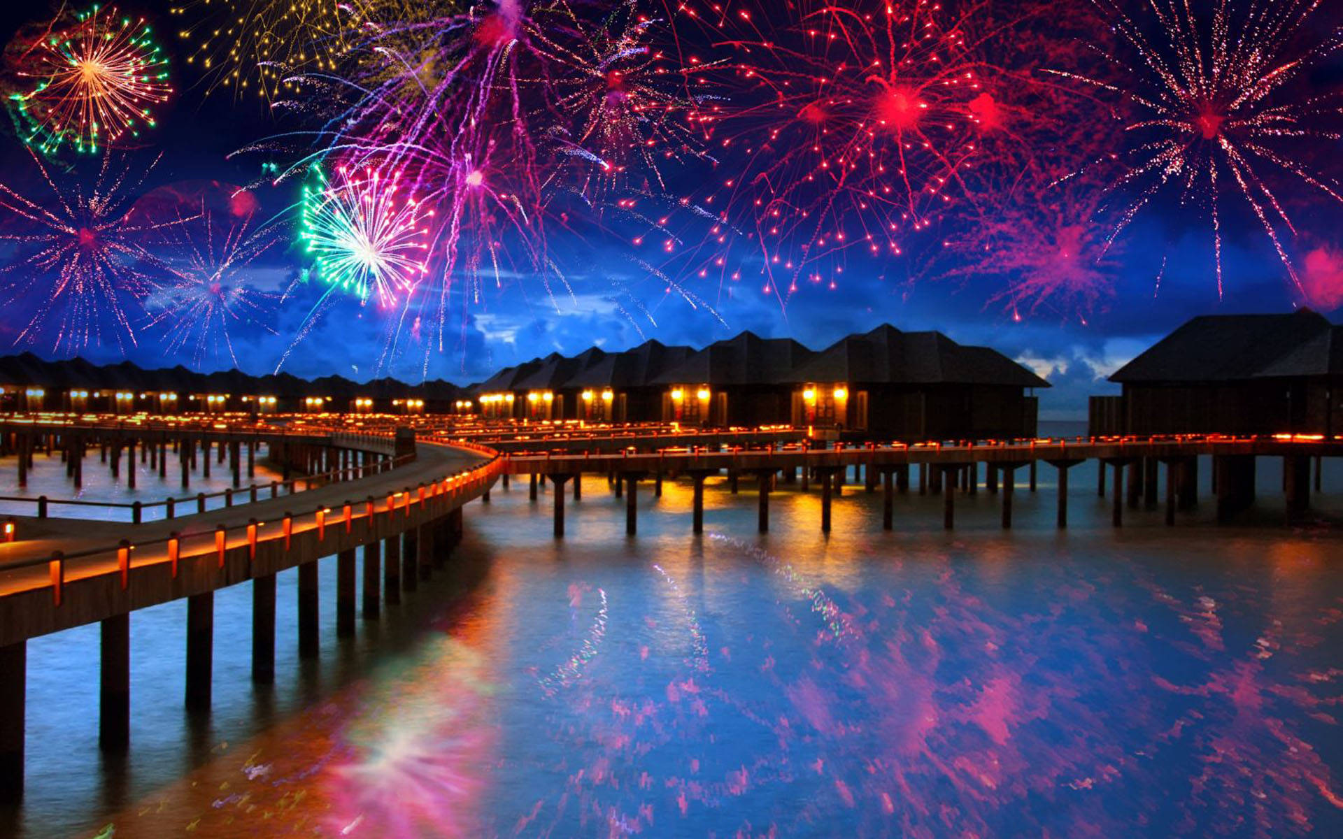Fireworks 桌布 壁紙 — 色彩繽紛的煙火在豪華水上度假村上空綻放，倒映在平靜的海面上。