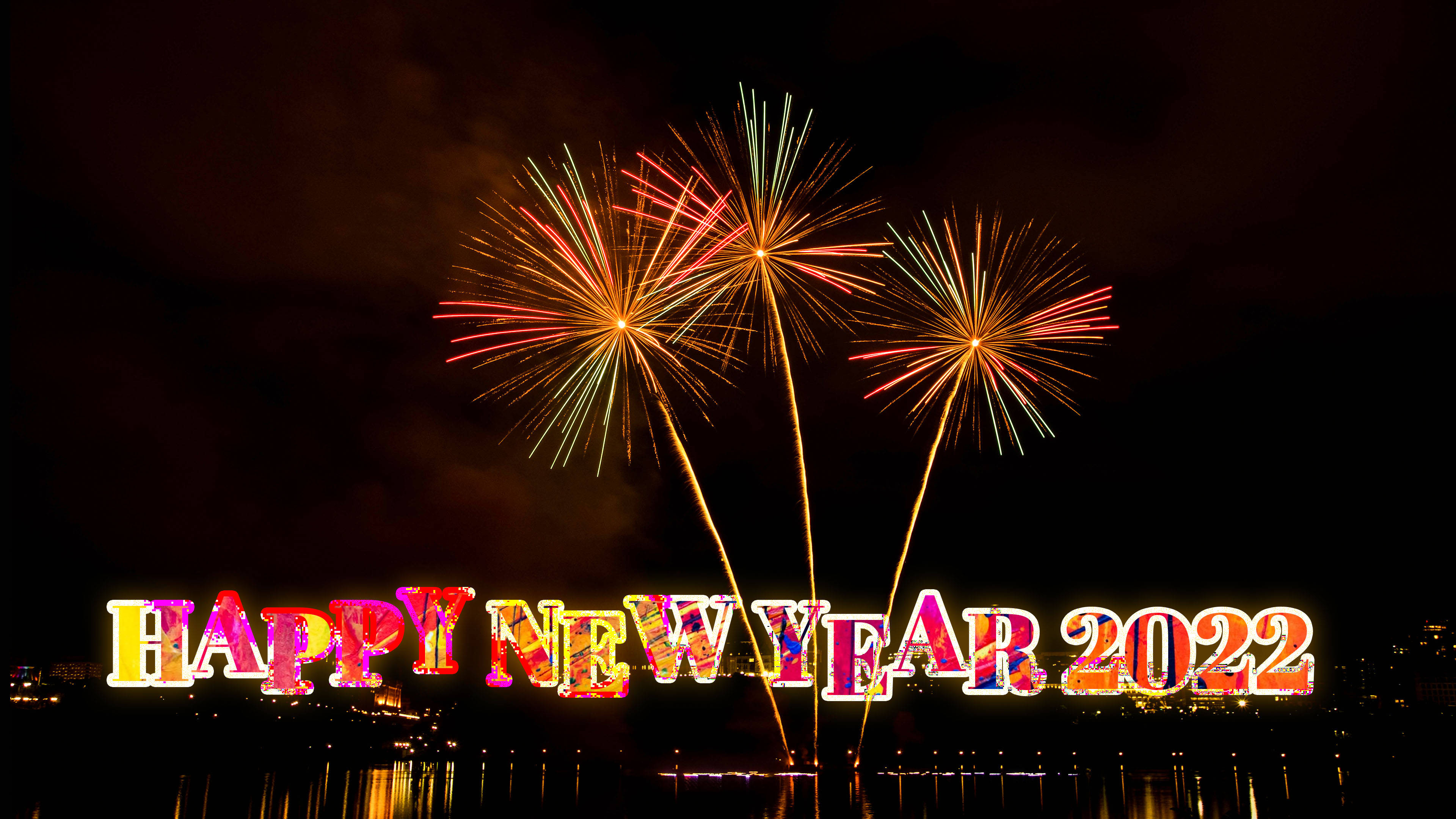 Happy New Year 2022 桌布 壁紙 — 色彩繽紛的煙火在黑暗的天空中爆炸，映照在水面上，'HAPPY NEW YEAR 2022' 以彩色字母閃耀。