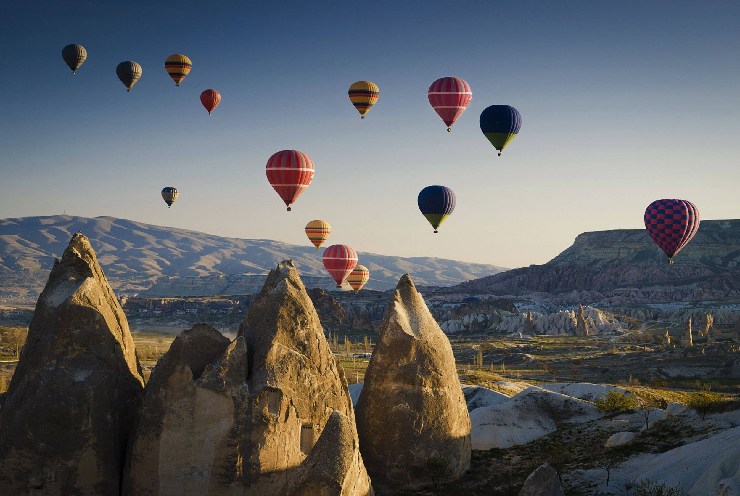 Cappadocia 桌布 壁紙 — 色彩繽紛的熱氣球在卡帕多奇亞的黃金時刻飄過標誌性的精靈煙囪。