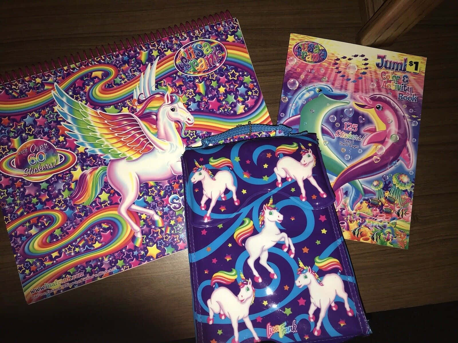 桌布 壁紙 — 色彩繽紛的獨角獸主題活動書和一個帶有彩虹翅膀和星星的小袋放在木質表面上。
