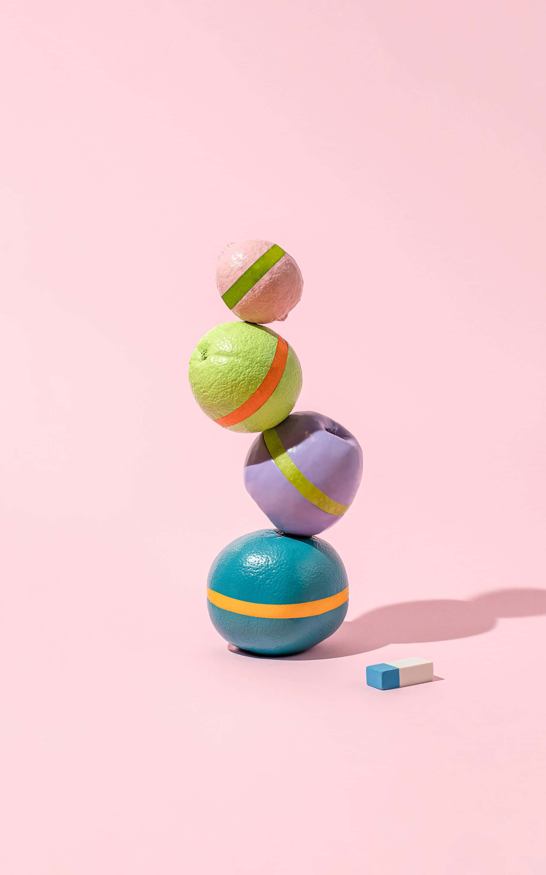 1848x2960 桌布 壁紙 — 色彩繽紛的球體堆疊在一起，帶有粗線條，在柔和的粉紅色背景上搖搖欲墜地保持平衡。