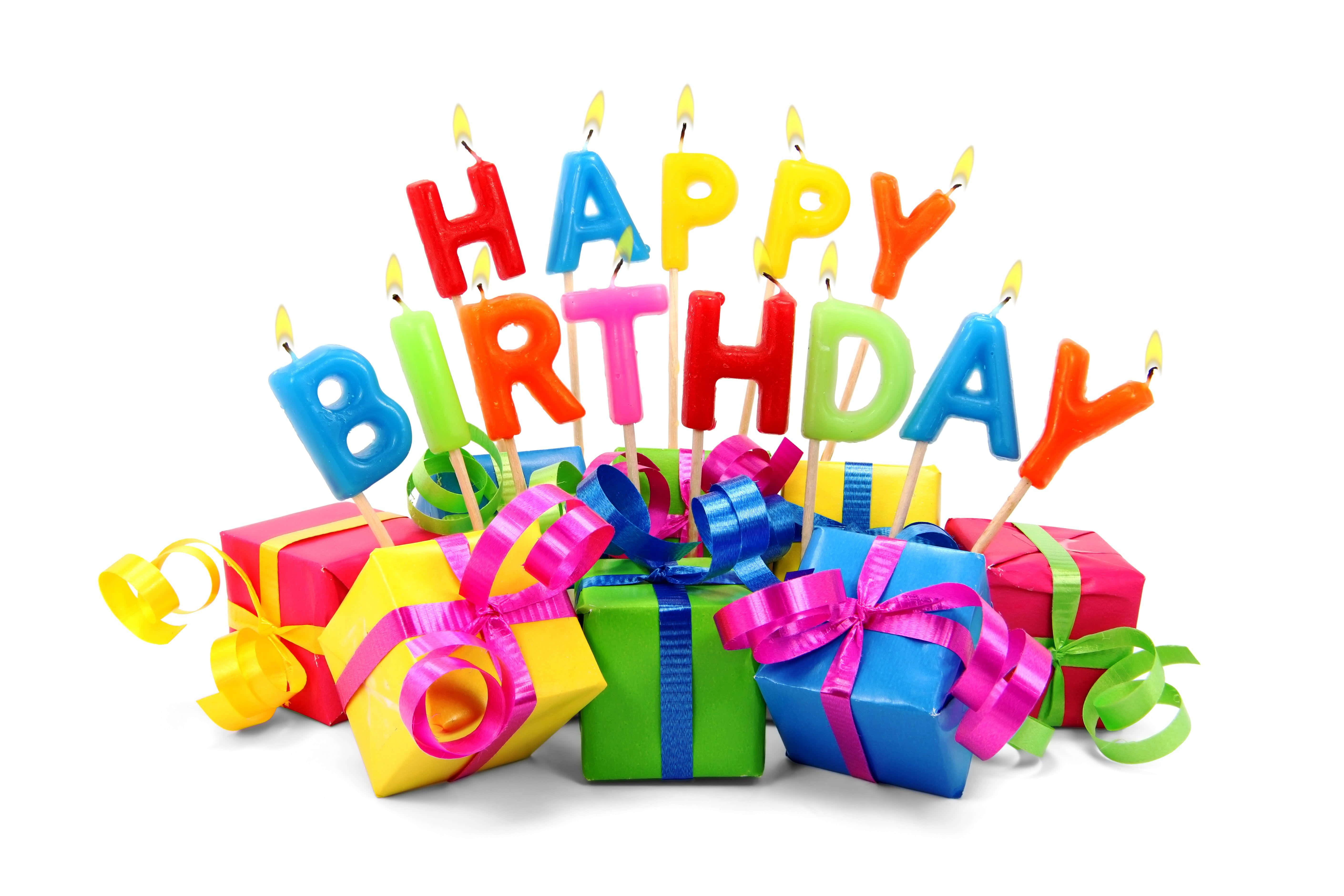 Birthday 桌布 壁紙 — 色彩繽紛的生日蠟燭拼出 happy birthday，聳立在一堆用閃亮絲帶包裝的禮物之上。