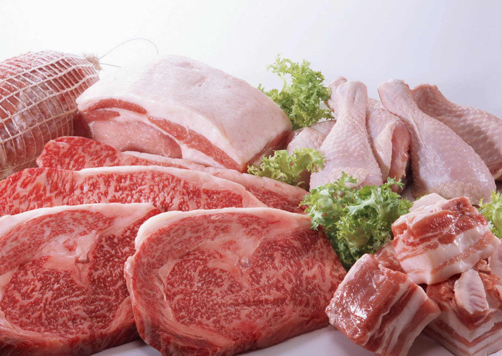 meat 桌布 壁紙 — 色彩繽紛的生肉展示，包括大理石紋的牛排、雞腿和豬肋排，搭配新鮮的綠色生菜裝飾。
