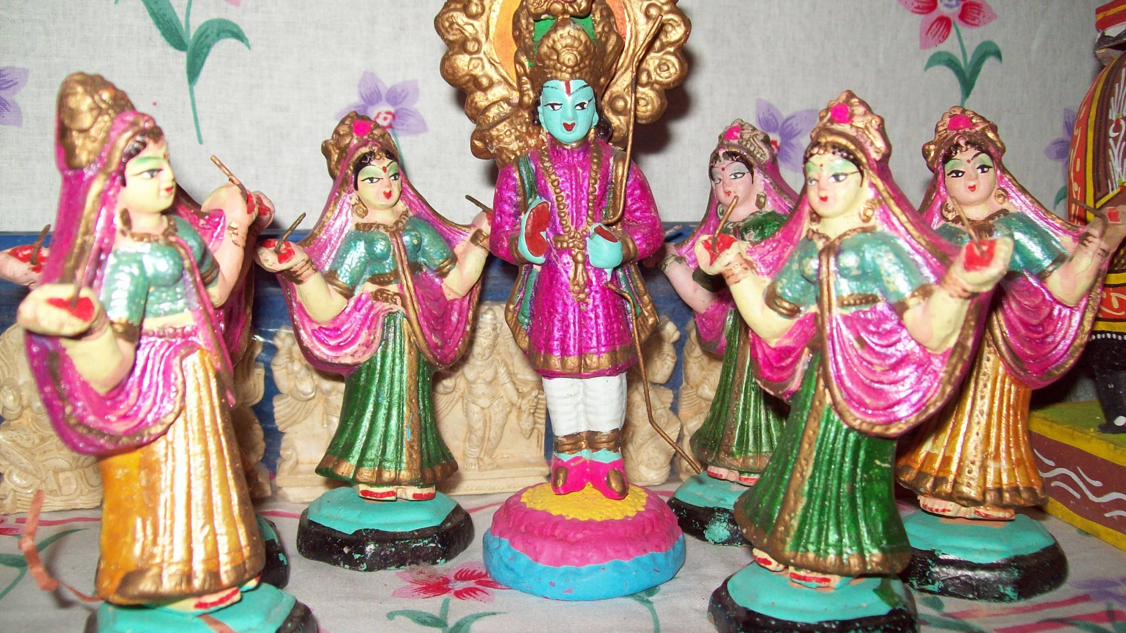 krishna ji 桌布 壁紙 — 色彩繽紛的粉紅色、綠色和金色繪製的印度教神靈和舞者雕像，整齊排列展示。