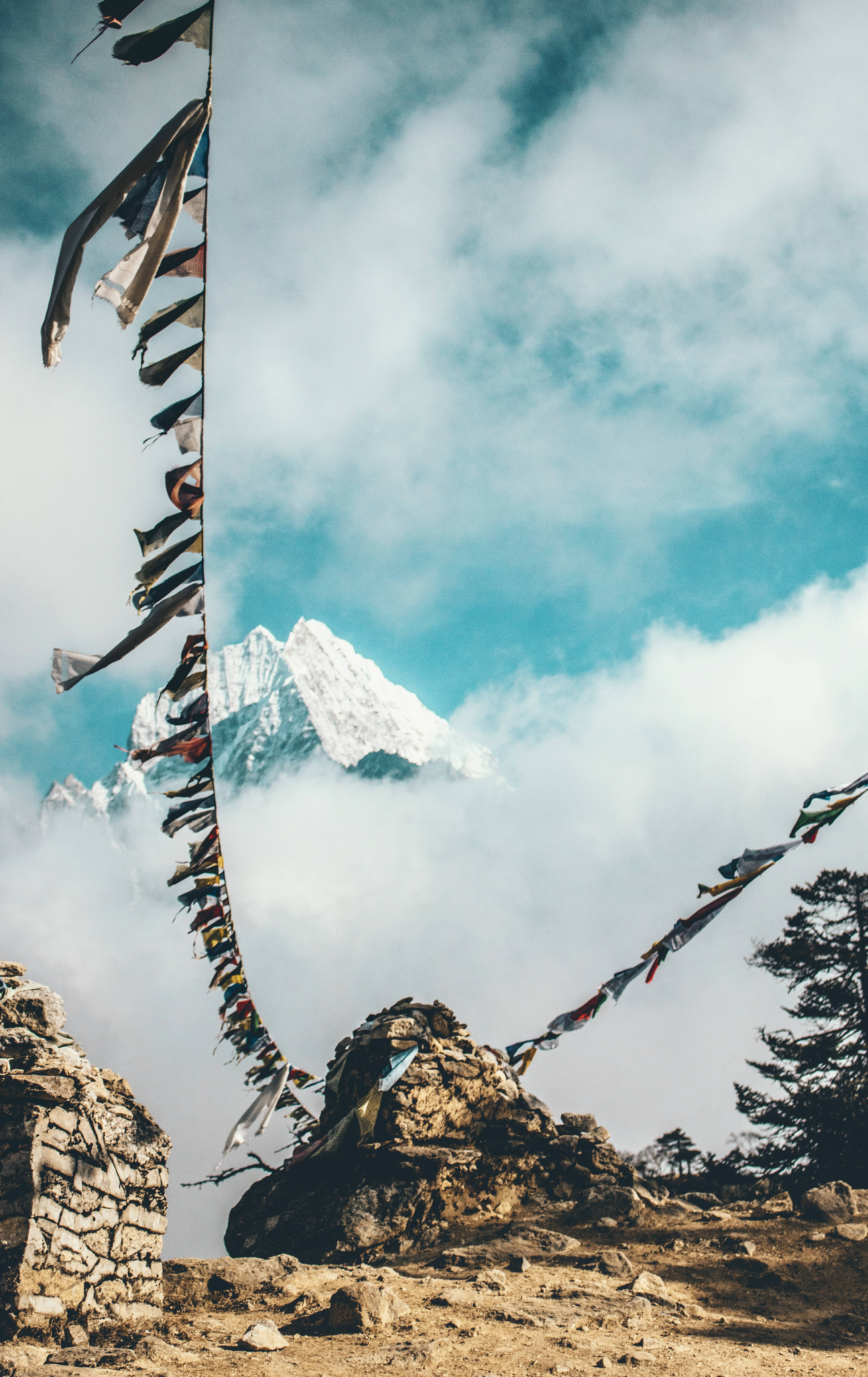 Nepal 桌布 壁紙 — 色彩繽紛的經幡在部分被雲霧遮蓋的雪山背景下飄揚。