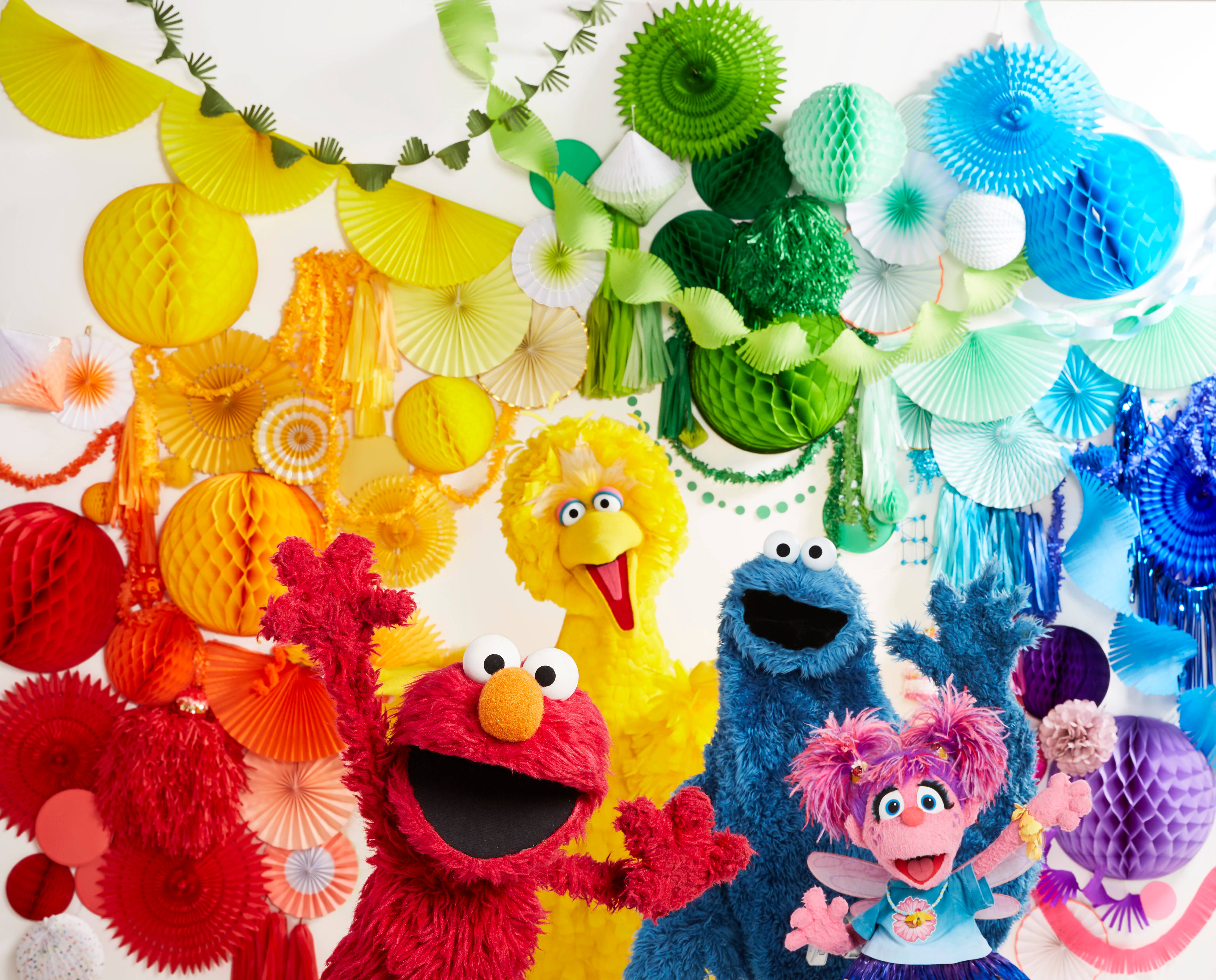 Elmo 桌布 壁紙 — 色彩繽紛的芝麻街布偶：艾摩、大鳥、餅乾怪獸和艾比·卡達比，在色彩繽紛的紙扇和蜂窩裝飾背景前愉快地擺姿勢。