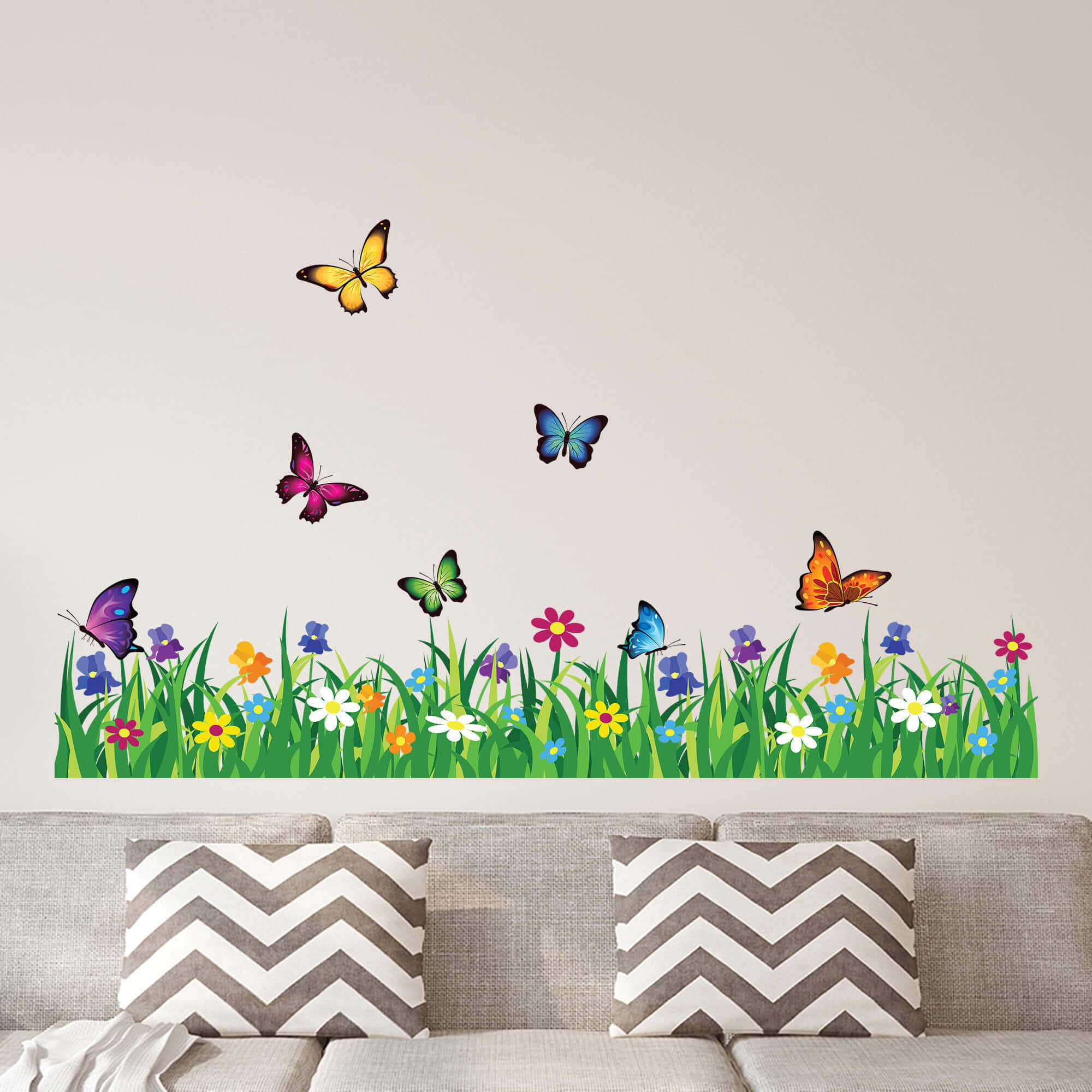 Wall Painting 桌布 壁紙 — 色彩繽紛的蝴蝶在充滿活力的花草草地上方飛舞，牆壁位於灰色沙發上方，沙發上有chevron圖案枕頭。