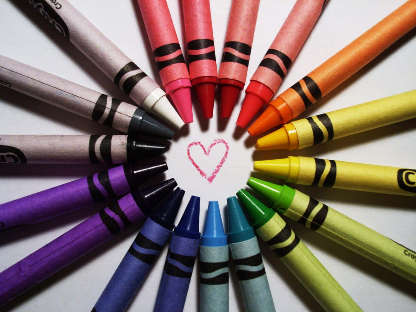 crayon 桌布 壁紙 — 色彩繽紛的蠟筆在白紙上排列成圓形，中央畫有一個粉紅色的心形。